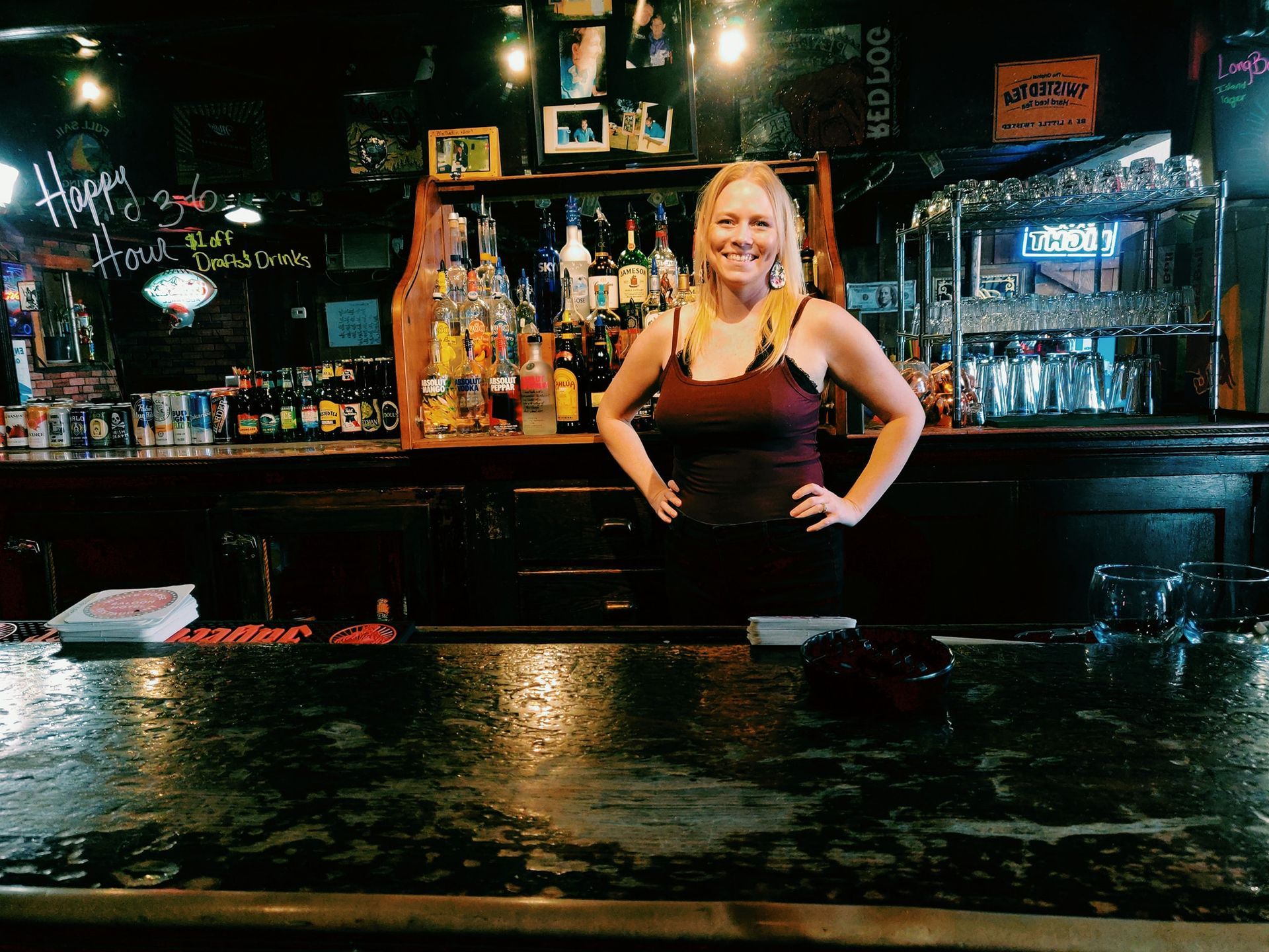 A woman is standing behind a bar in a bar