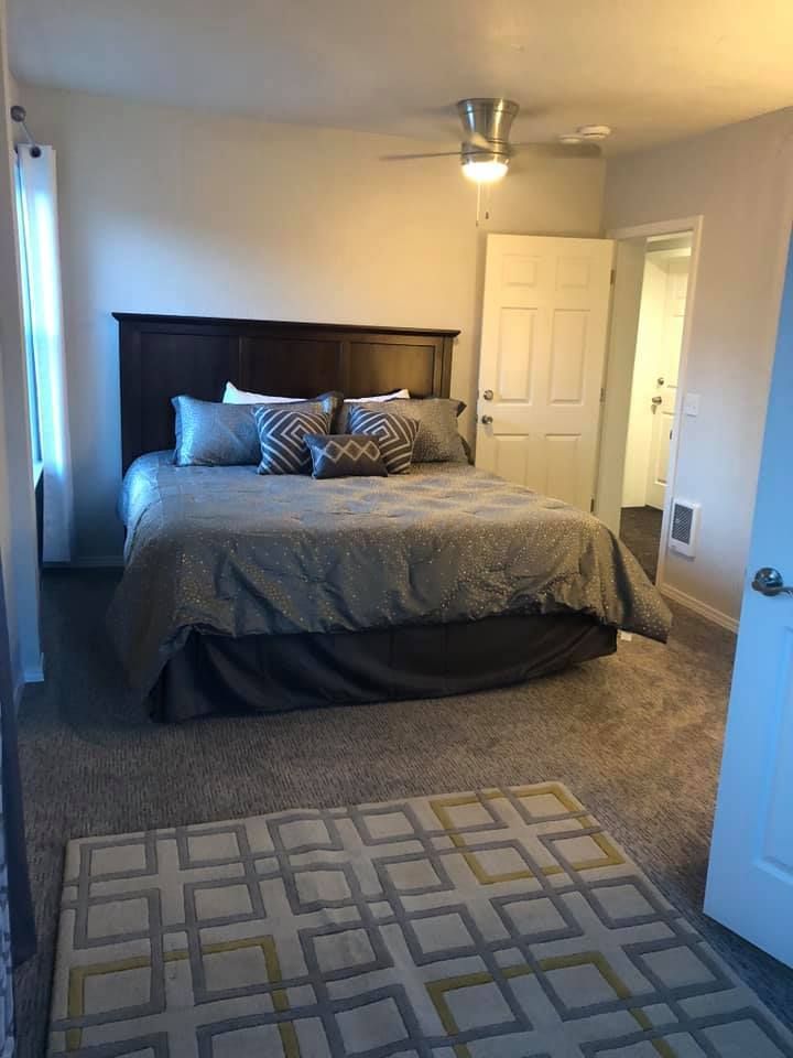 A bedroom with a king size bed and a rug.
