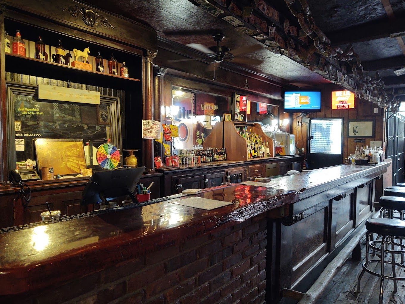 A bar with a long wooden counter and stools