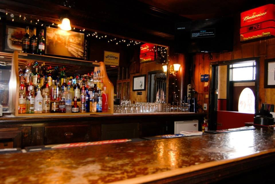A bar with a budweiser sign on the wall