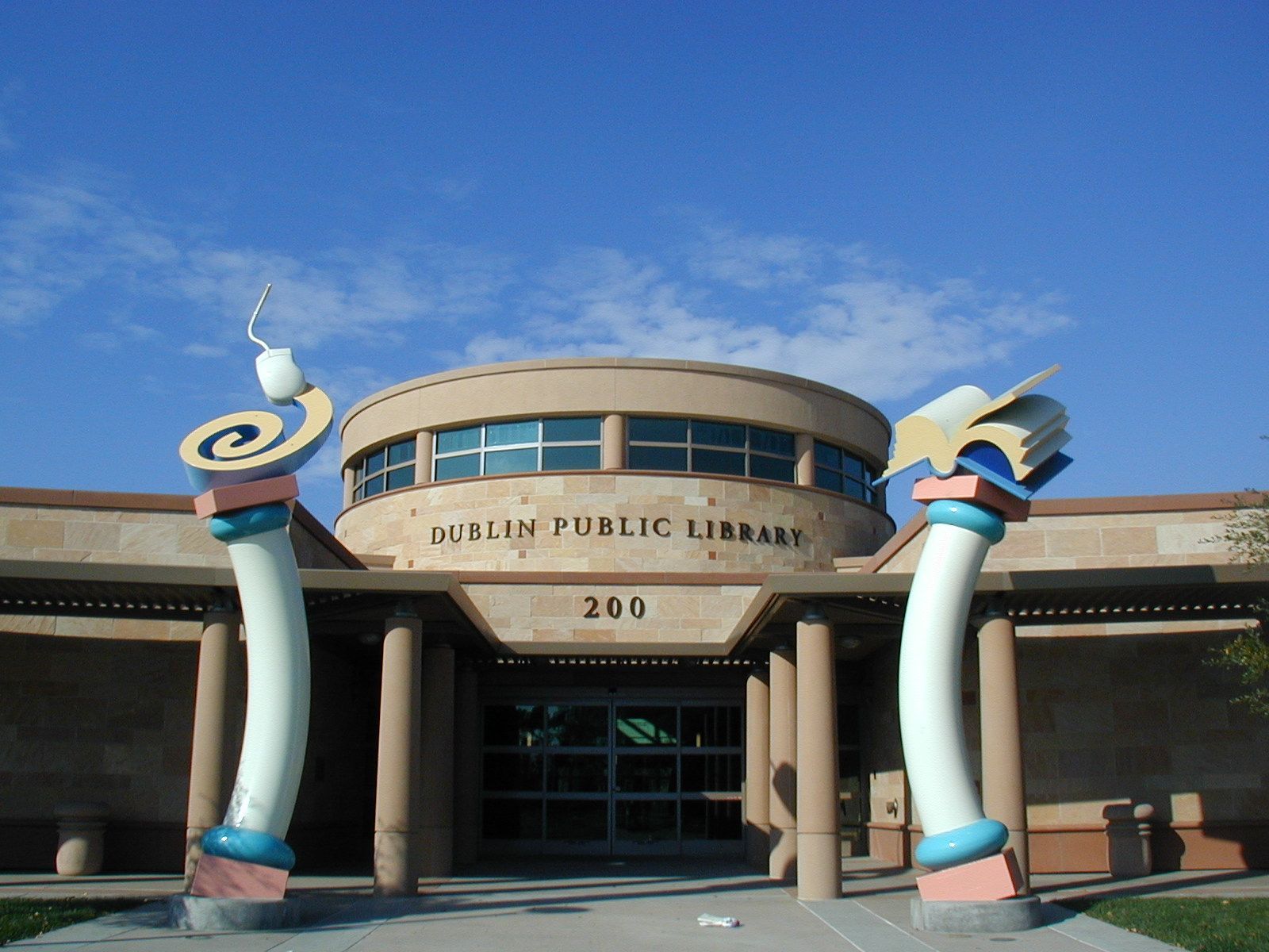 Duncan Public Library entrance with two colorful inflatable tube figures under a blue sky
