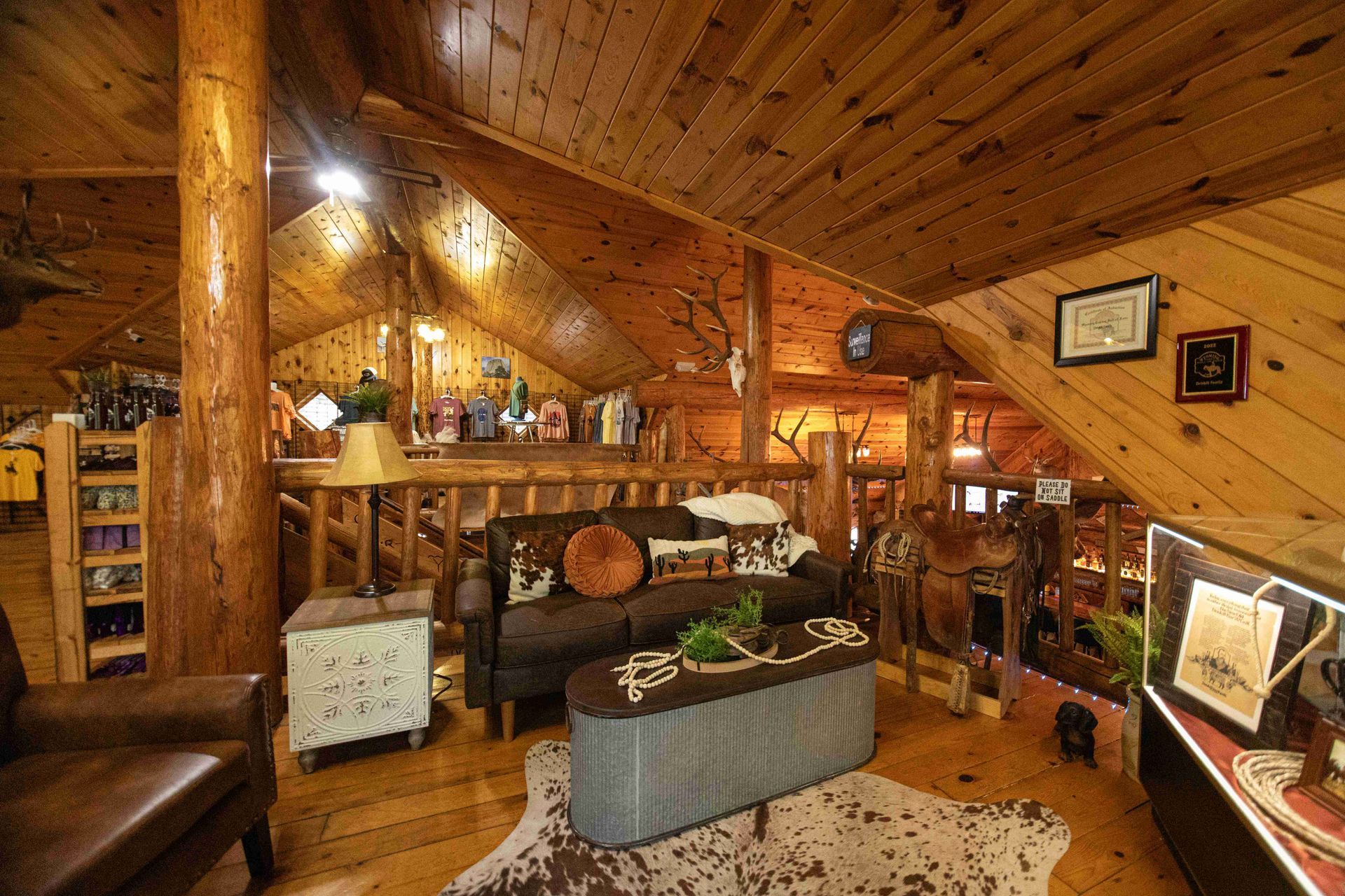 Cozy wooden cabin living room with shelves, couch, rug, and warm ambient lighting