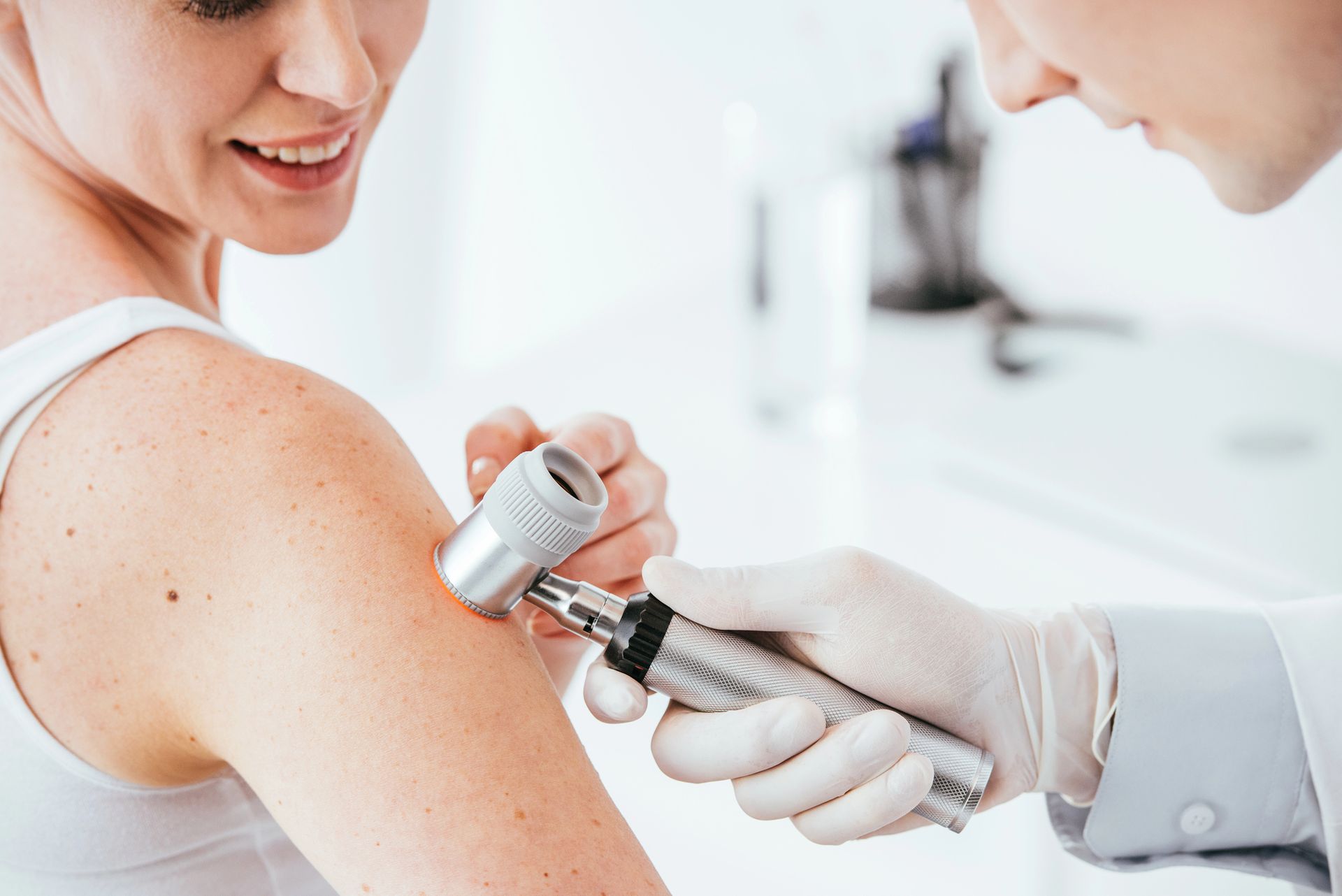Medico che esamina la pelle di un paziente con un dermatoscopio. Ambiente ambulatoriale con forniture mediche.