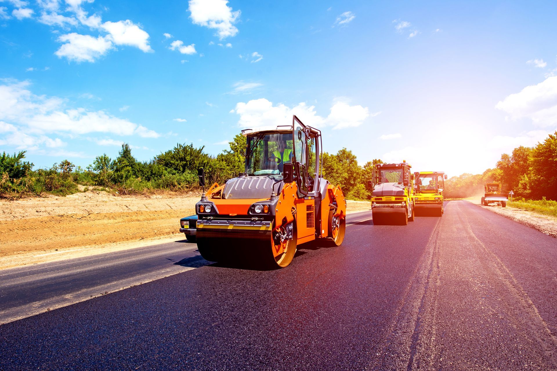 Road rollers compacting fresh asphalt on a sunny day. Road rollers compacting fresh asphalt on a sunny day.