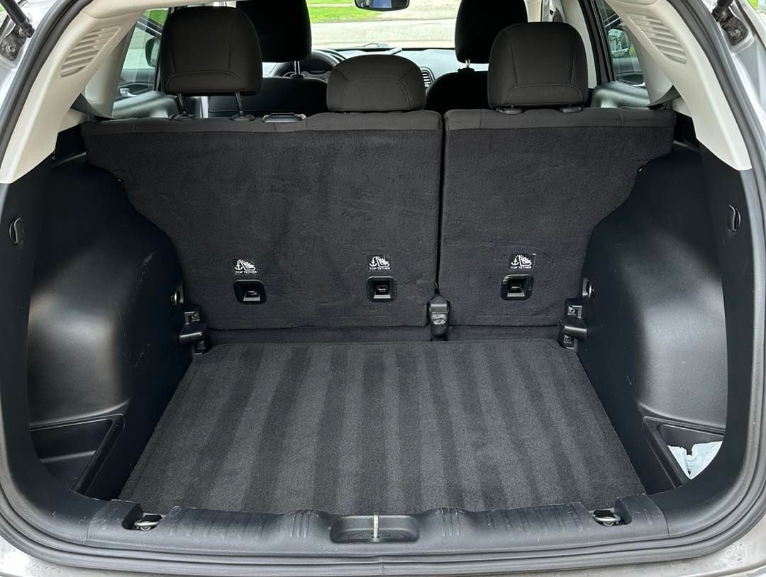 Empty cargo area of a gray SUV, showing floor and back of the rear seats.