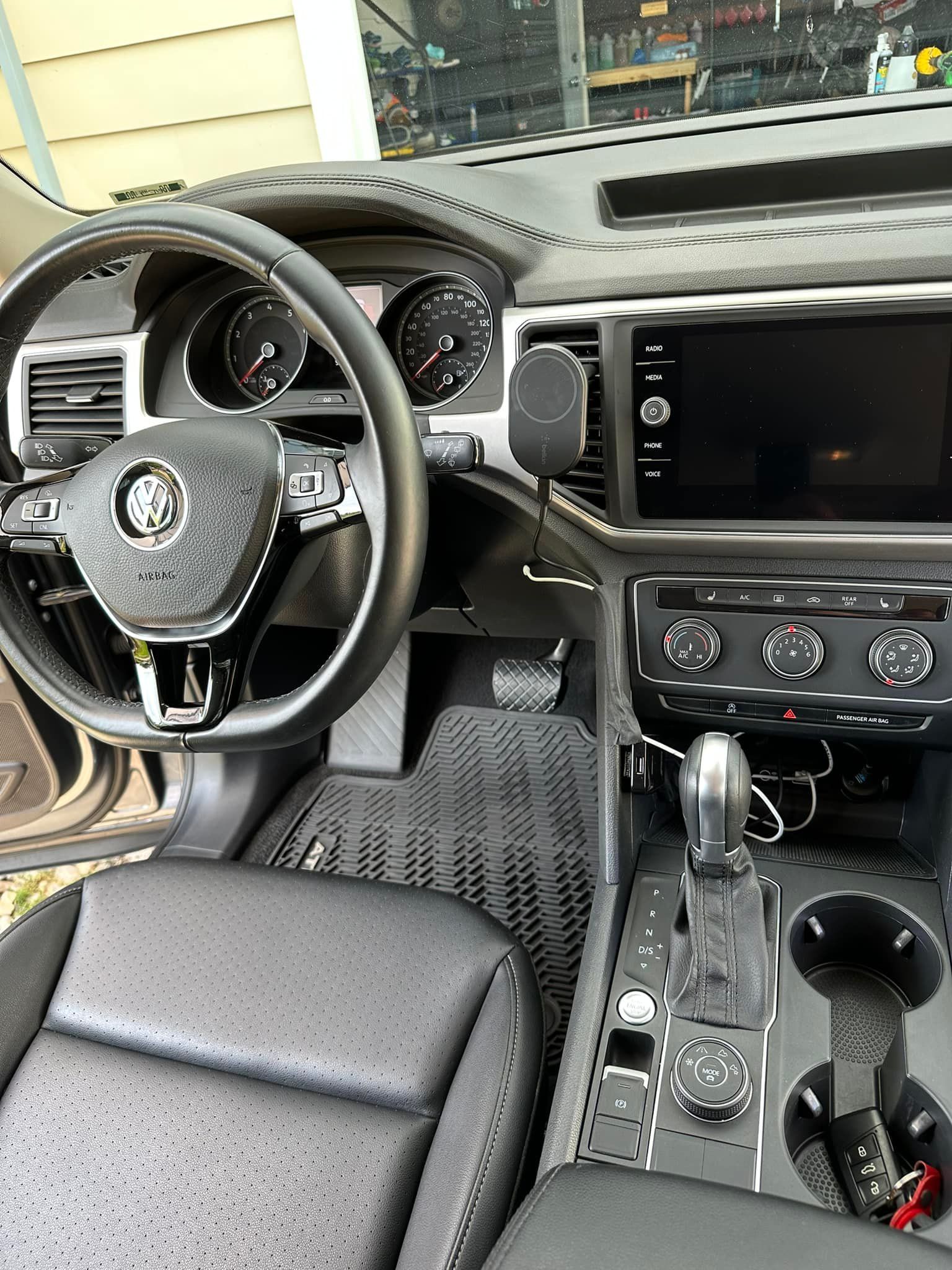 Interior of a Volkswagen Atlas SUV with a black dashboard, steering wheel, and infotainment screen.