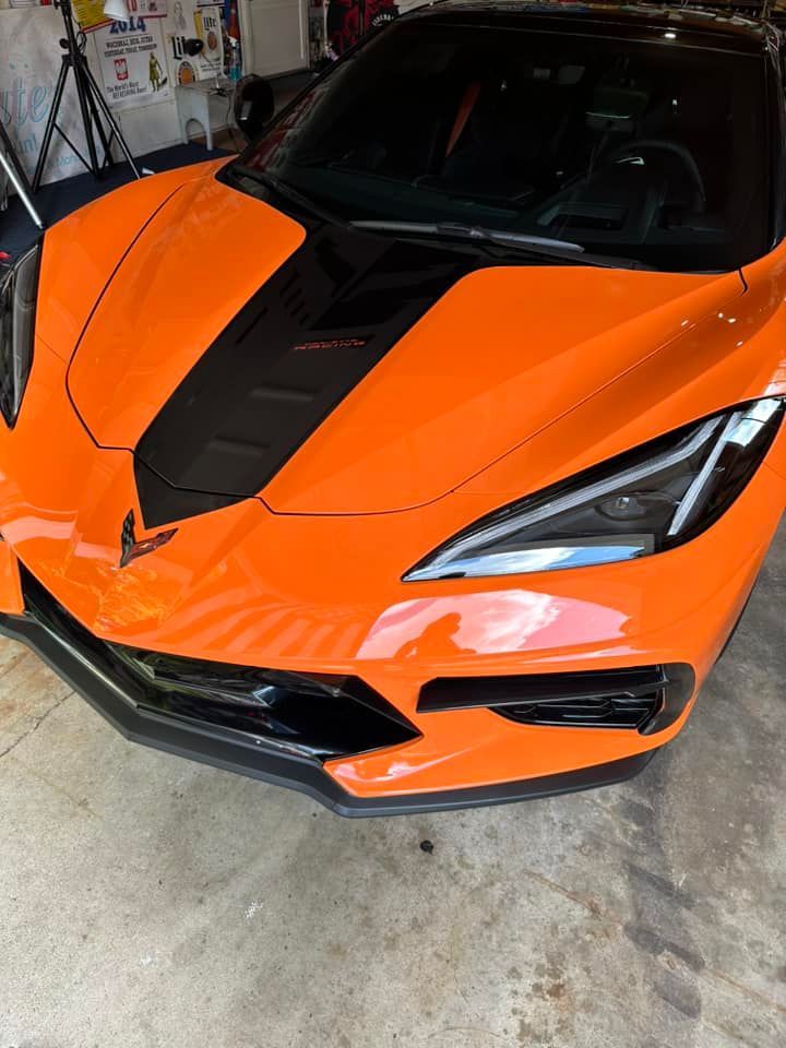 Orange and black Chevrolet Corvette sports car in a garage.