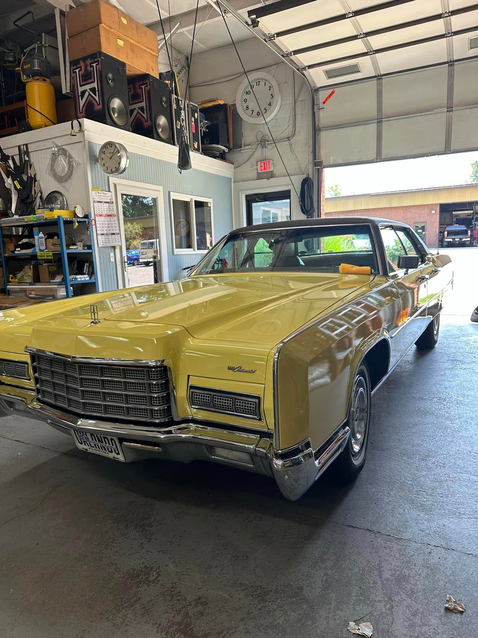 Yellow classic car parked inside a garage.