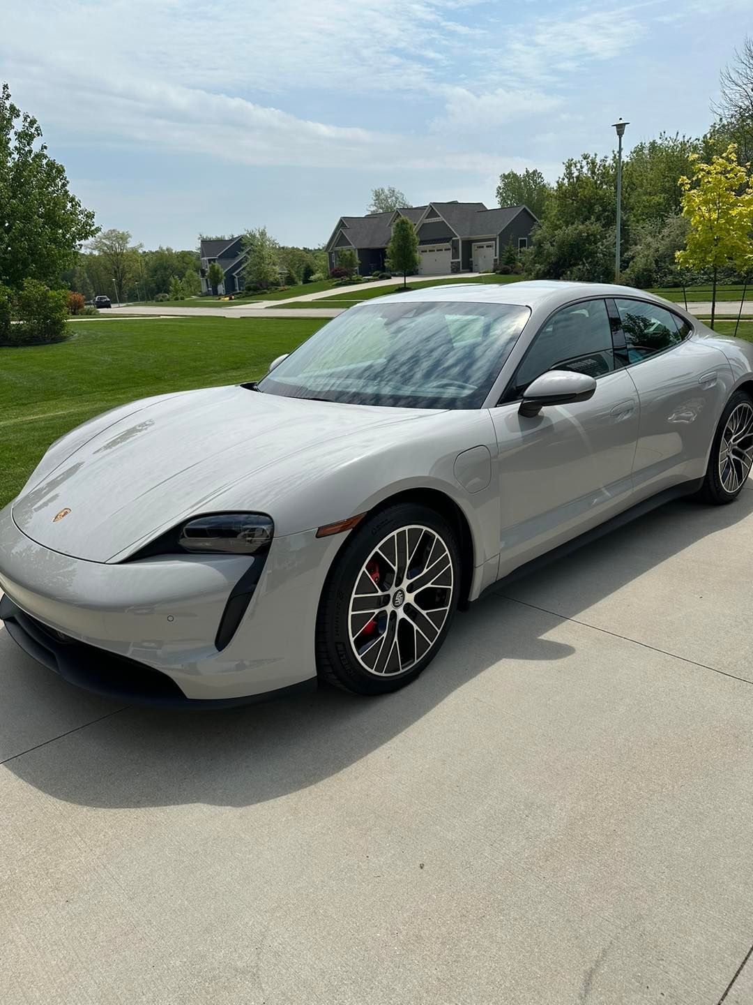 Gray Porsche Taycan electric car parked on a driveway.
