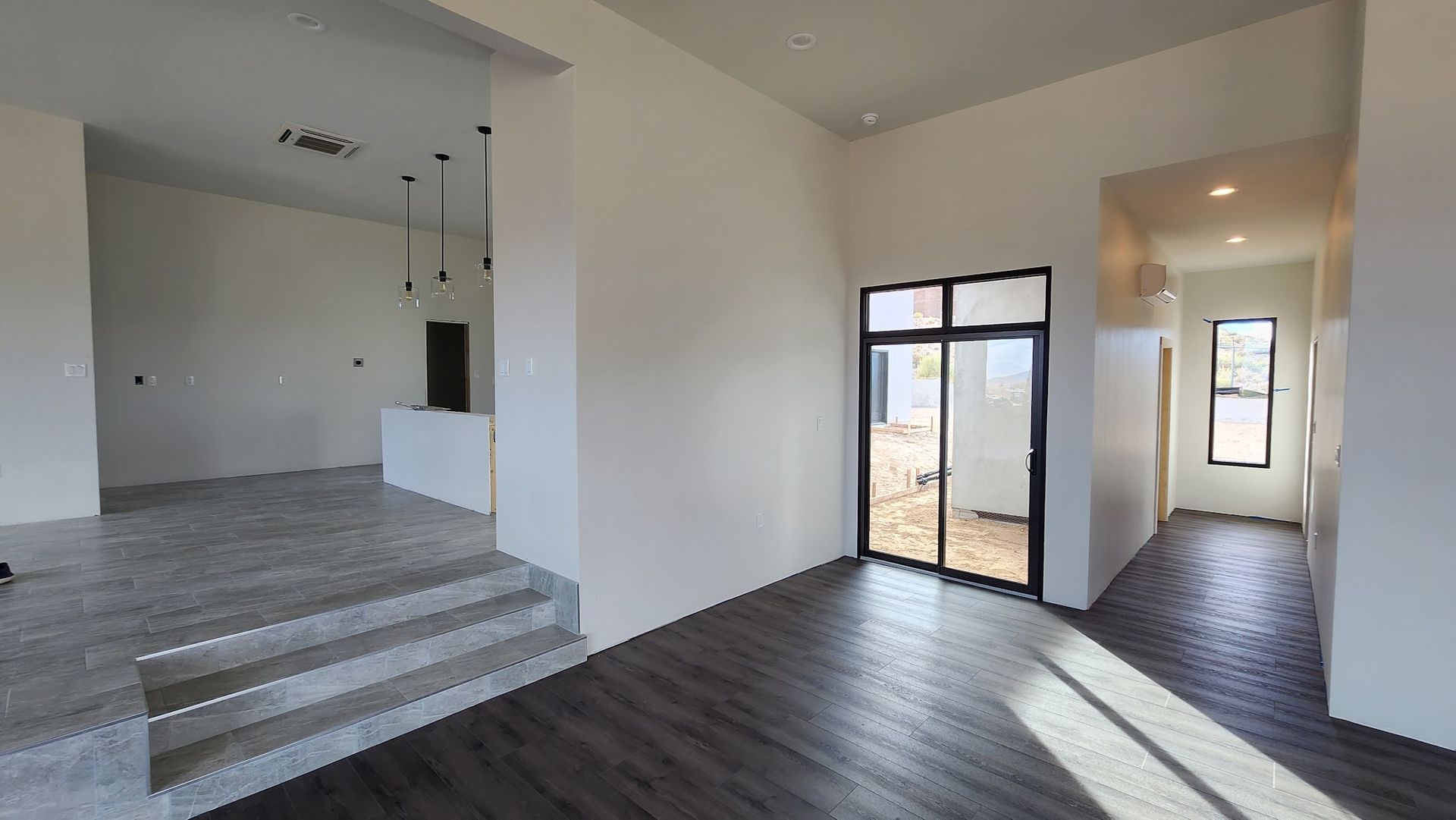 Indoor lobby with glass entrance doors opening to an outdoor courtyard and parked car.