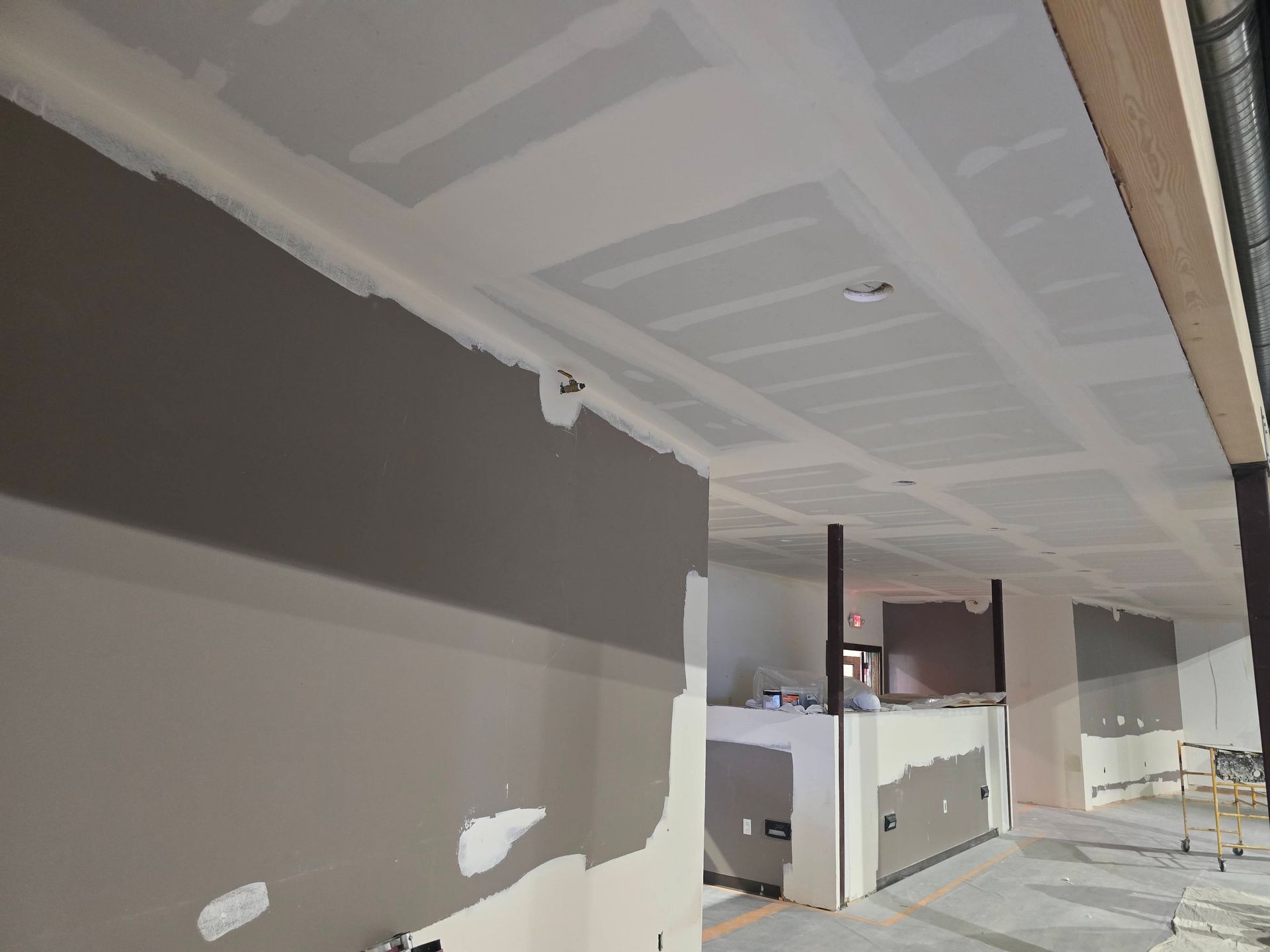Partially finished hallway with drywall, taped seams, and cabinets under construction