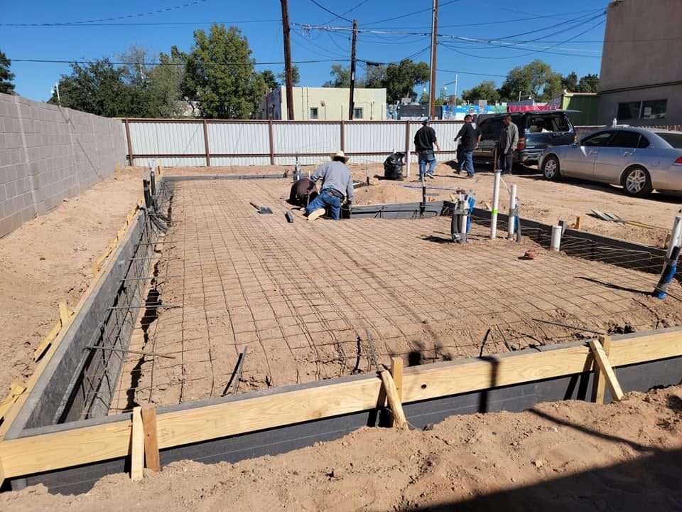 Construction workers laying a brick patio on a sunny residential lot