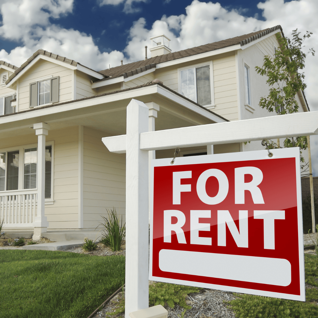 A house with a for rent sign in front of it