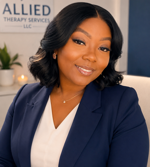 Professional woman smiling in a navy blazer and white blouse in an office setting