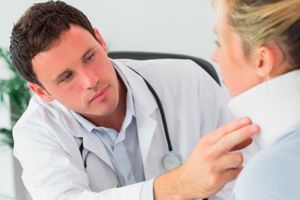 A doctor is examining a patient 's neck in an office.