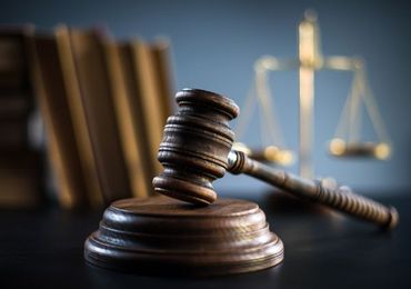 A judge 's gavel and scales of justice are on a table.