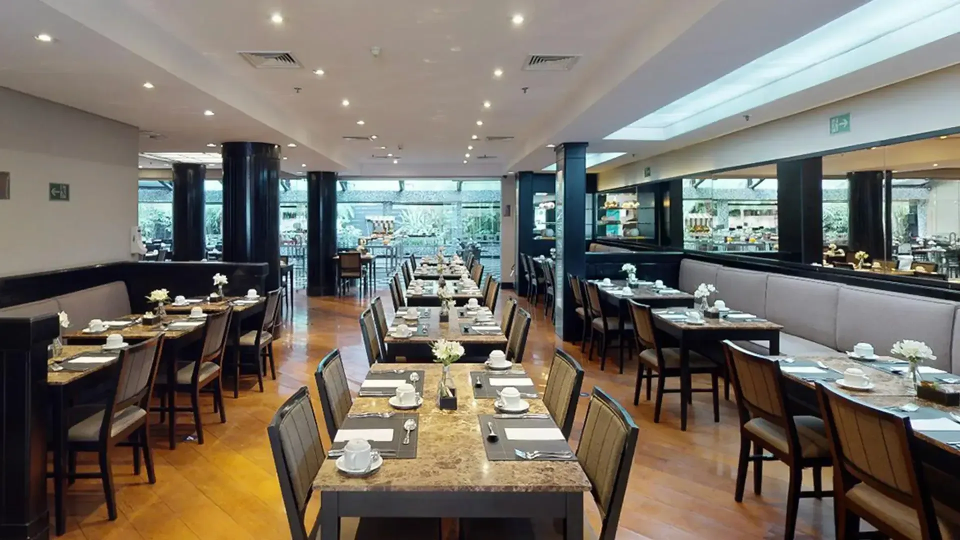 um restaurante com mesas e cadeiras preparadas para uma refeição.