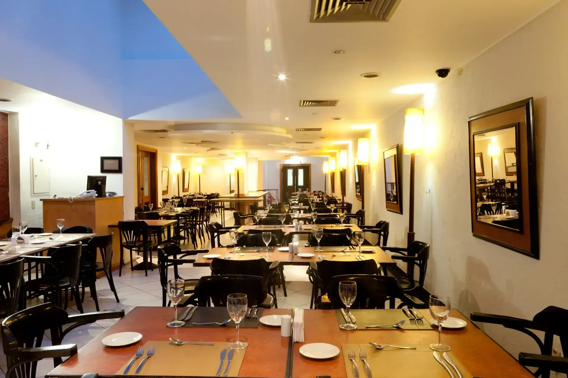 um restaurante com mesas e cadeiras preparadas para o jantar