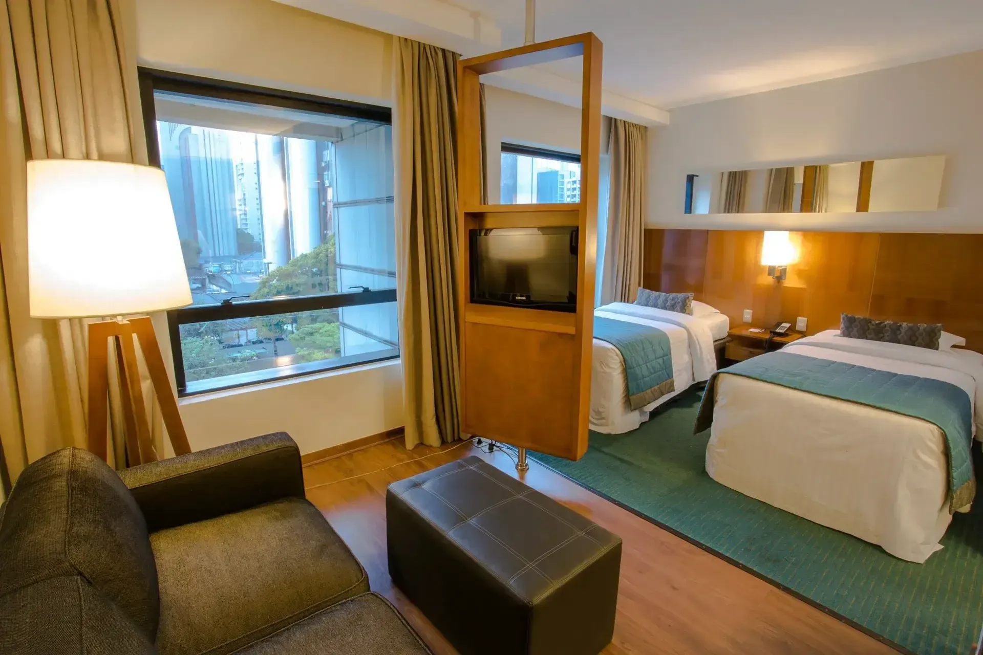 um quarto de hotel com duas camas, um sofá e uma televisão.