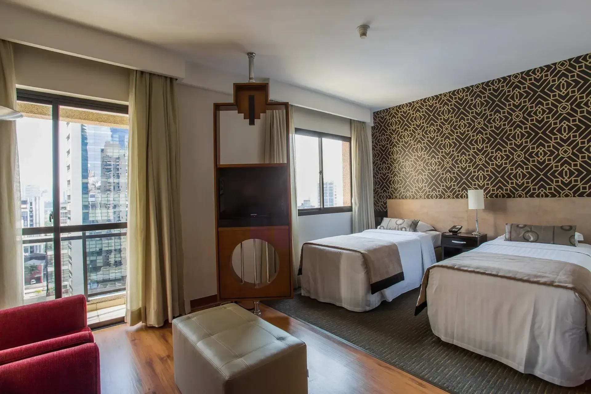 um quarto de hotel com duas camas, um sofá, uma televisão e uma varanda.