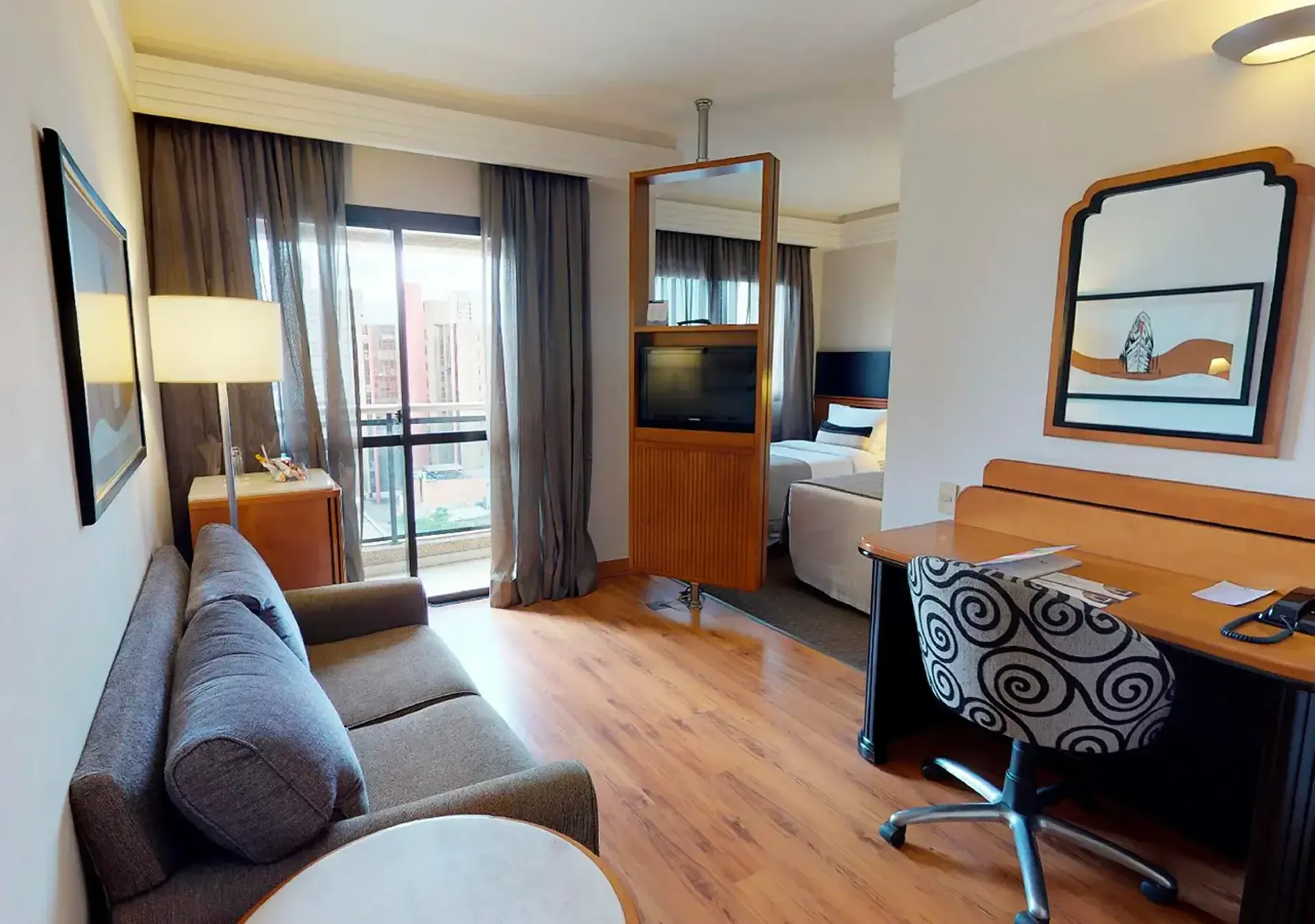um quarto de hotel com sofá, mesa e cadeira