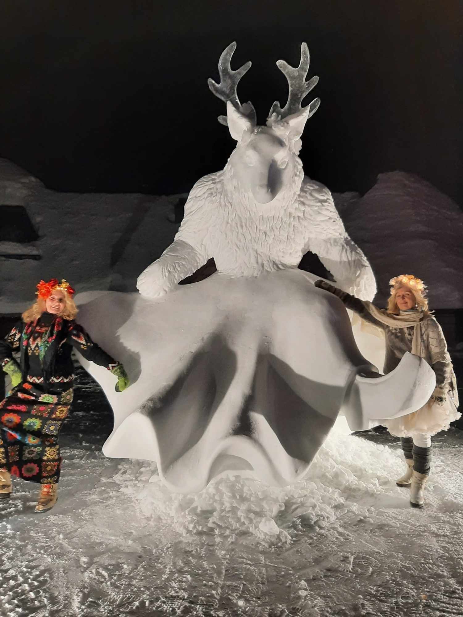 Tjåsa Lucia Gusfors står med en konstnärskollega framför en stor skulptur i snö.