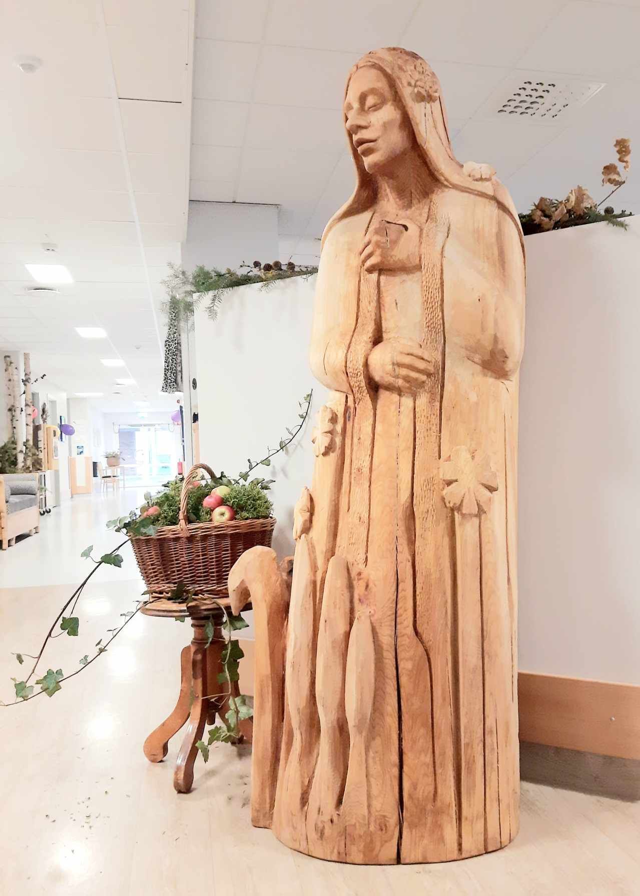 träskulptur av Tjåsa Lucia Gusfors på ett äldreboende i Motala, föreställande en kvinna