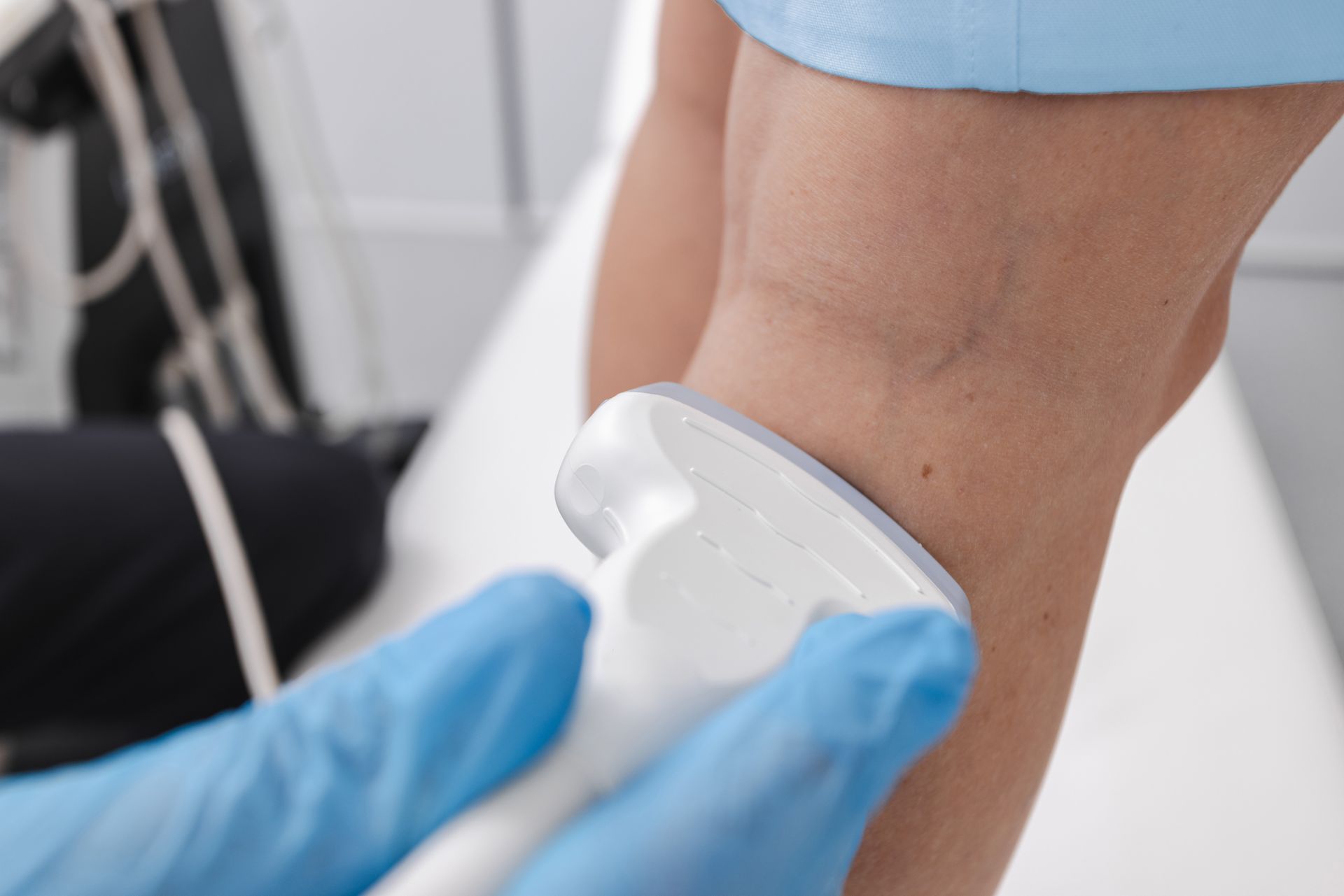 Clinician performing ultrasound evaluation of a patient's leg for vein disease. Clinician performing ultrasound evaluation of a patient's leg for vein disease.