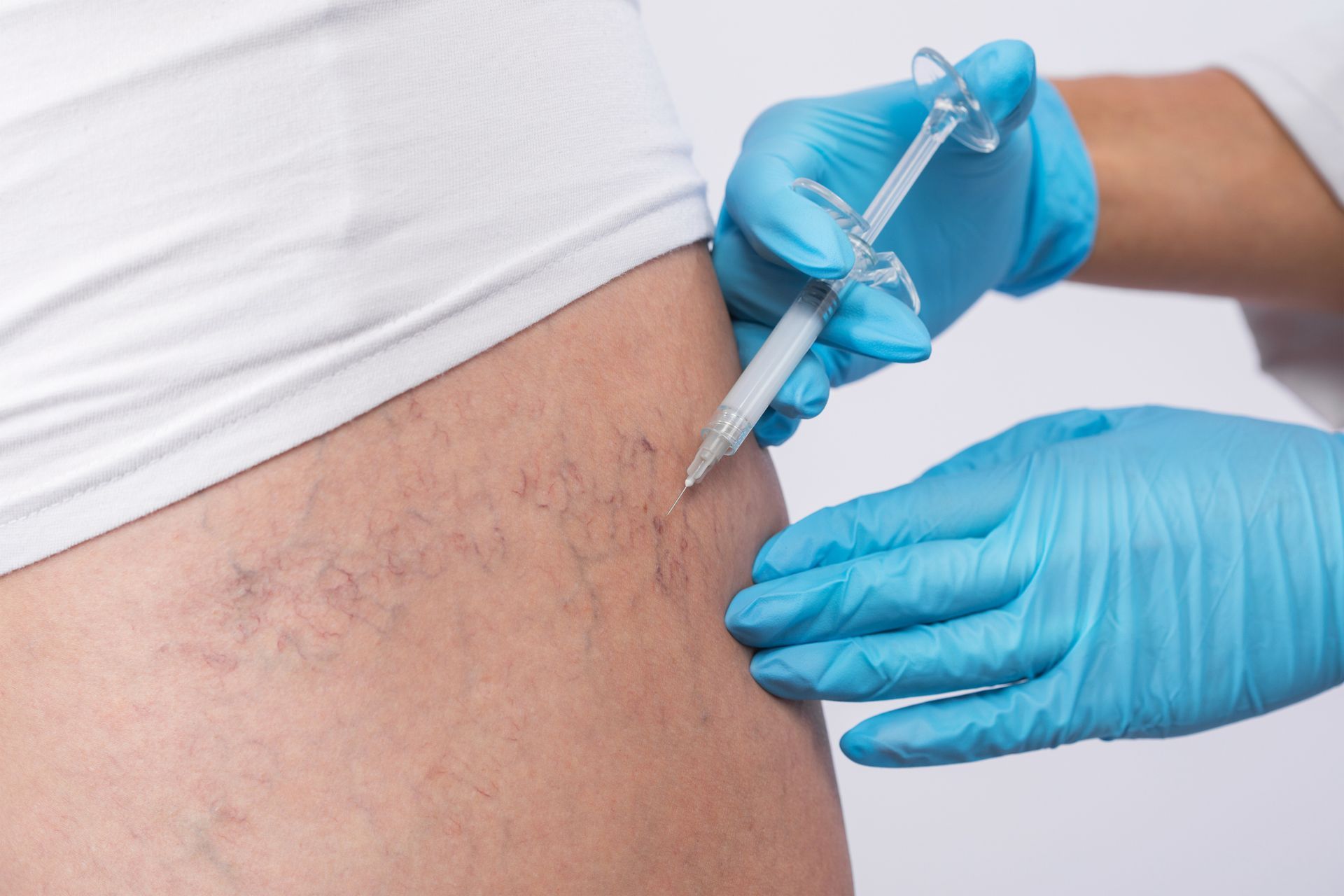 A woman is getting an injection in her leg.