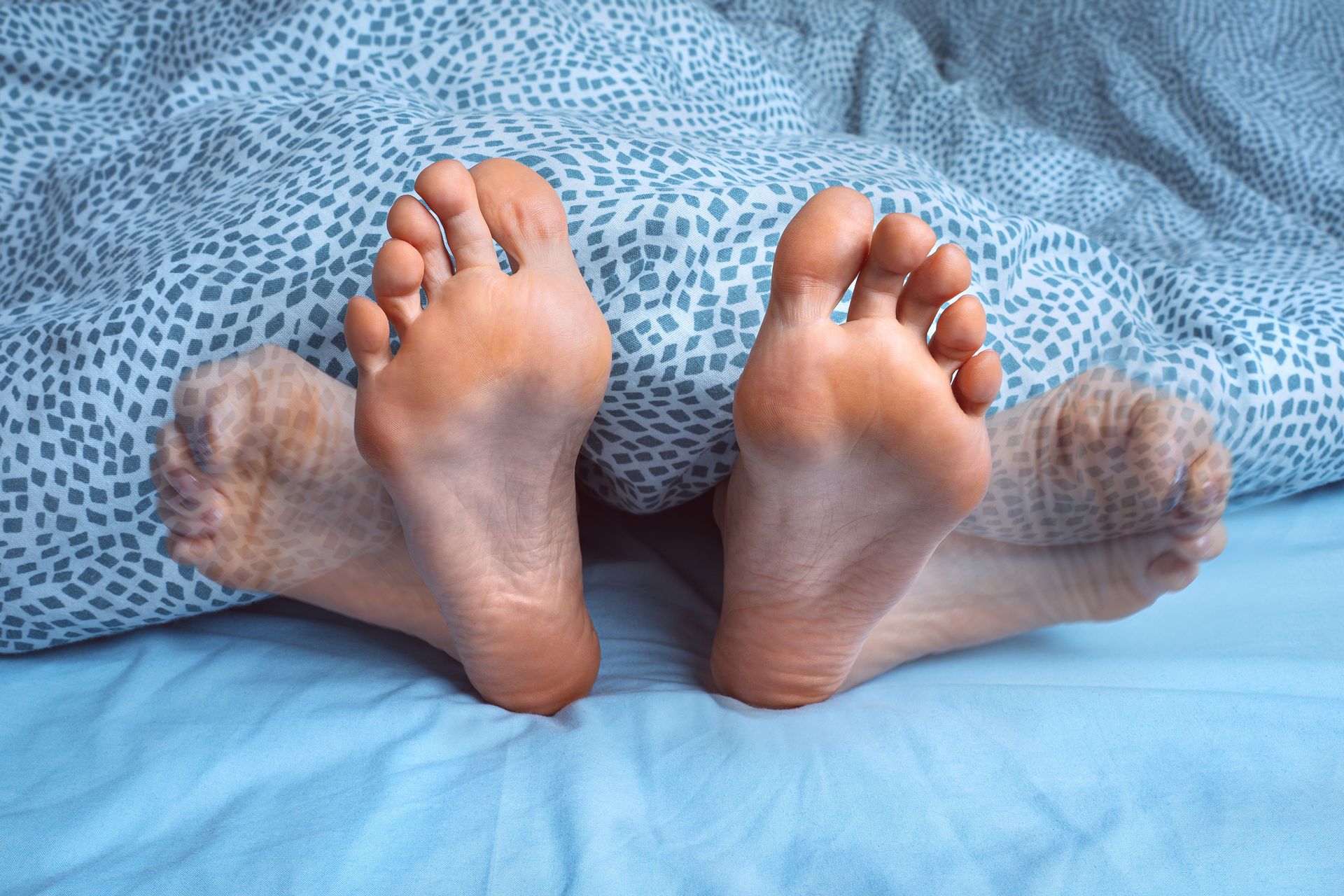 A child 's bare feet are standing on a wooden floor.