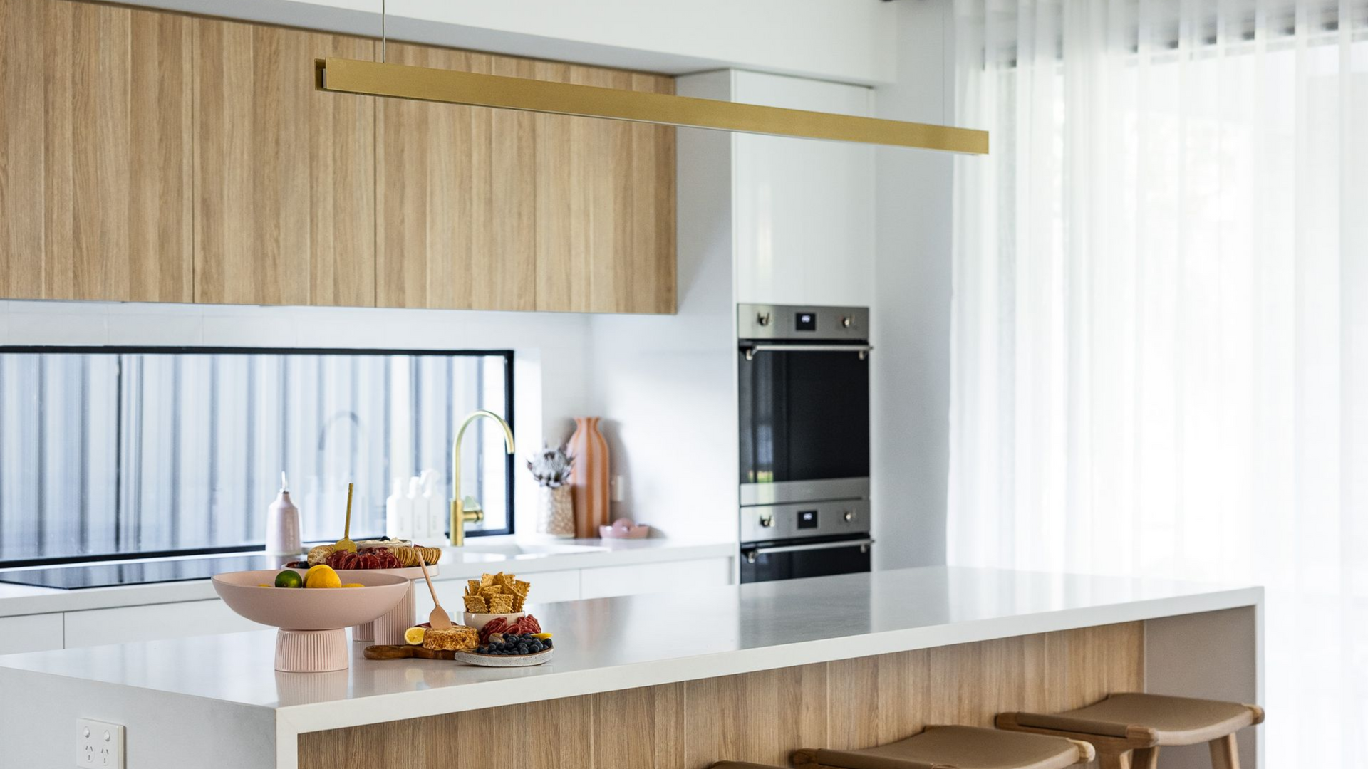 Modern Kitchen with White Island, Wood Cabinets, and Fruit Bowls on The Counter — JDS Kitchens & Detailed Joinery in Albion Park Rail, NSW