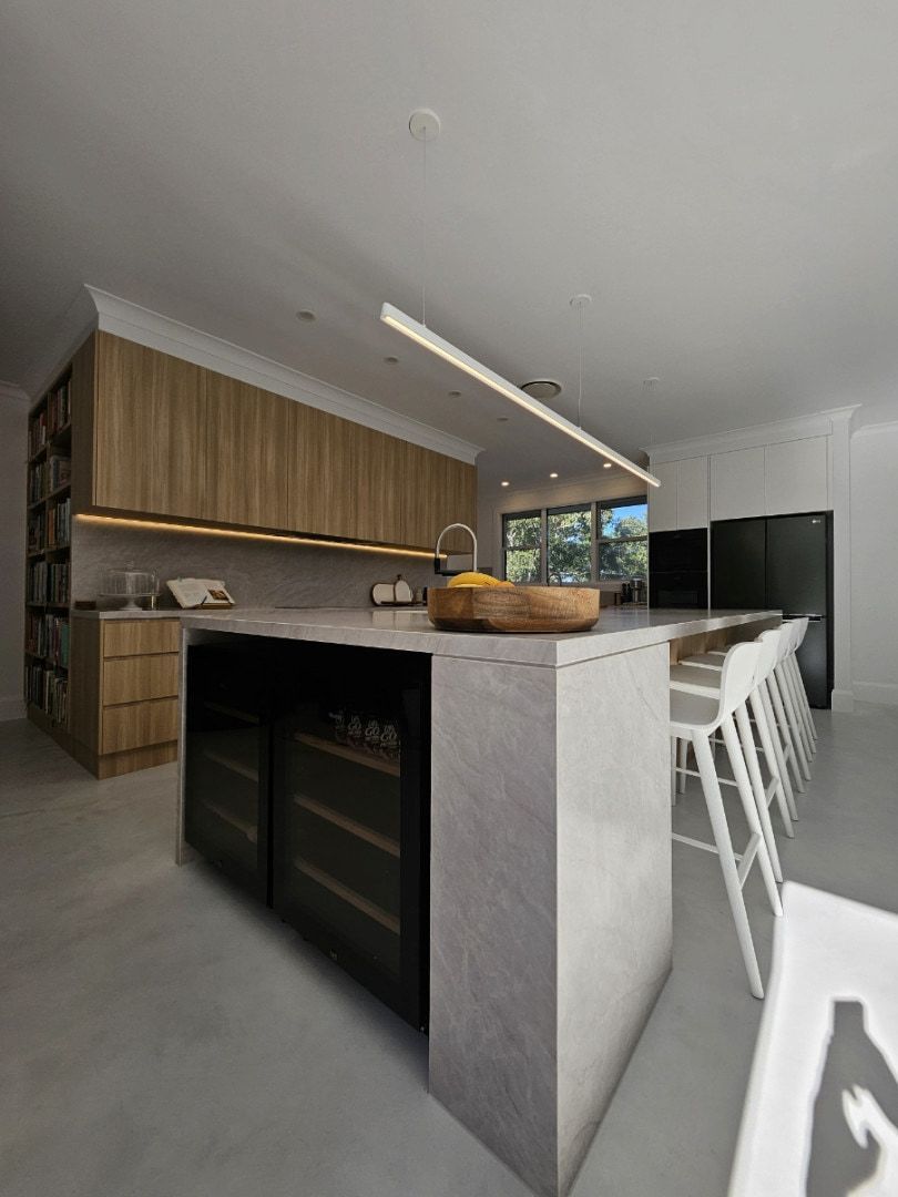 Kitchen With a Grey Island, Wood Cabinetry, and Bar Stools — JDS Kitchens & Detailed Joinery in Albion Park Rail, NSW