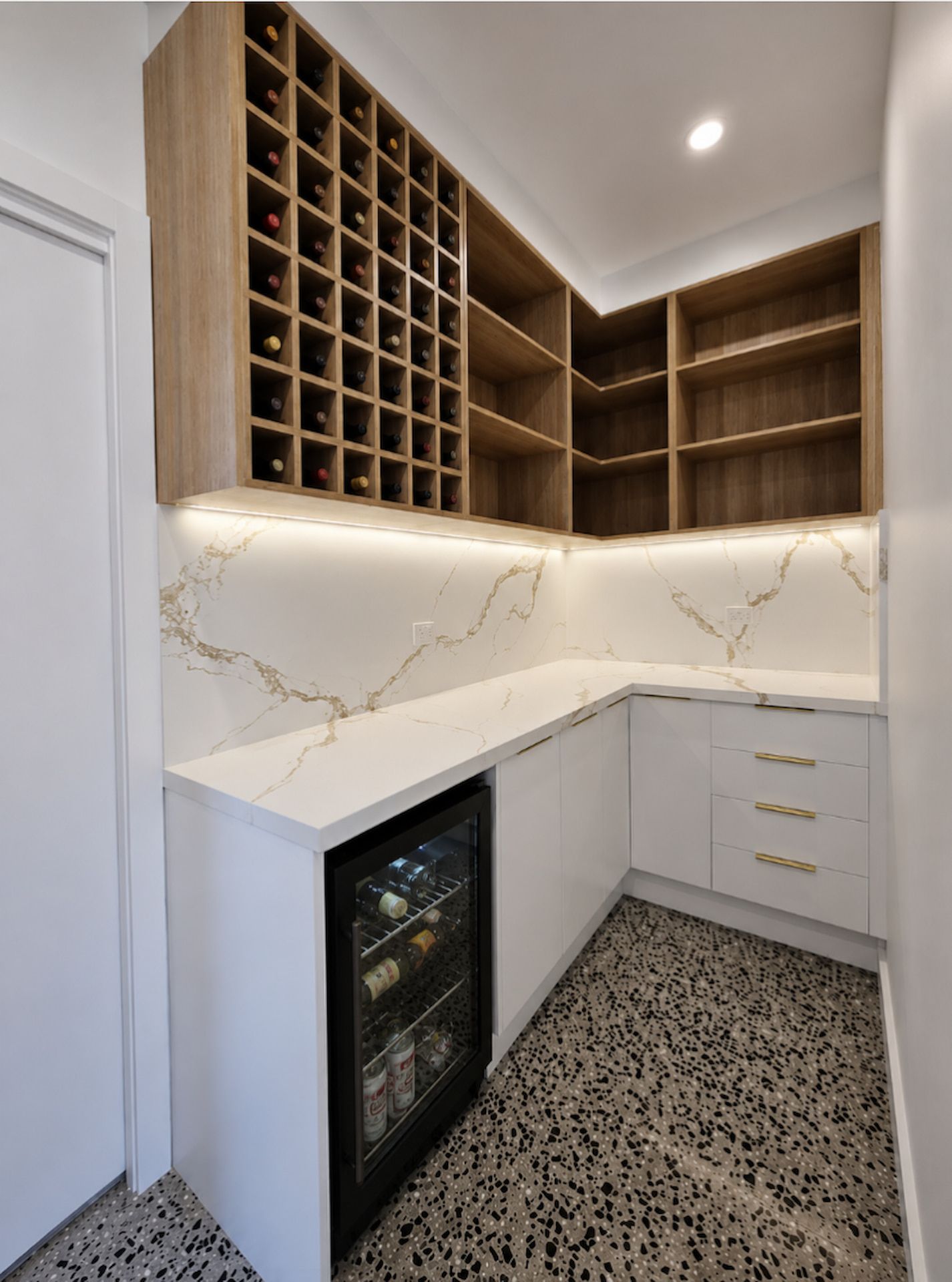 Modern L-Shaped Kitchen Corner with Wood Shelving, White Marble-Look Counters, and A Glass Wine Fridge — JDS Kitchens & Detailed Joinery in Albion Park Rail, NSW