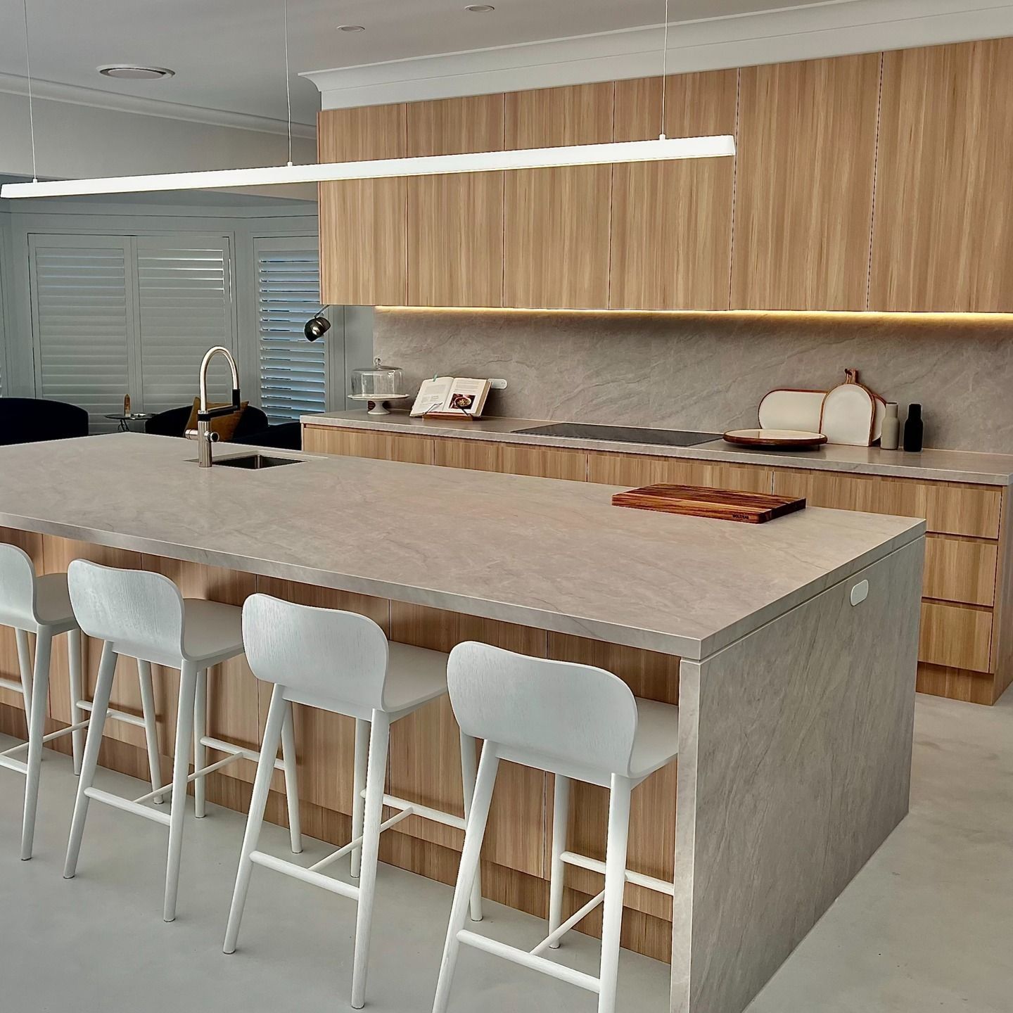 Kitchen With a Large Island, Four White Stools, and Wood Cabinets — JDS Kitchens & Detailed Joinery in Albion Park Rail, NSW