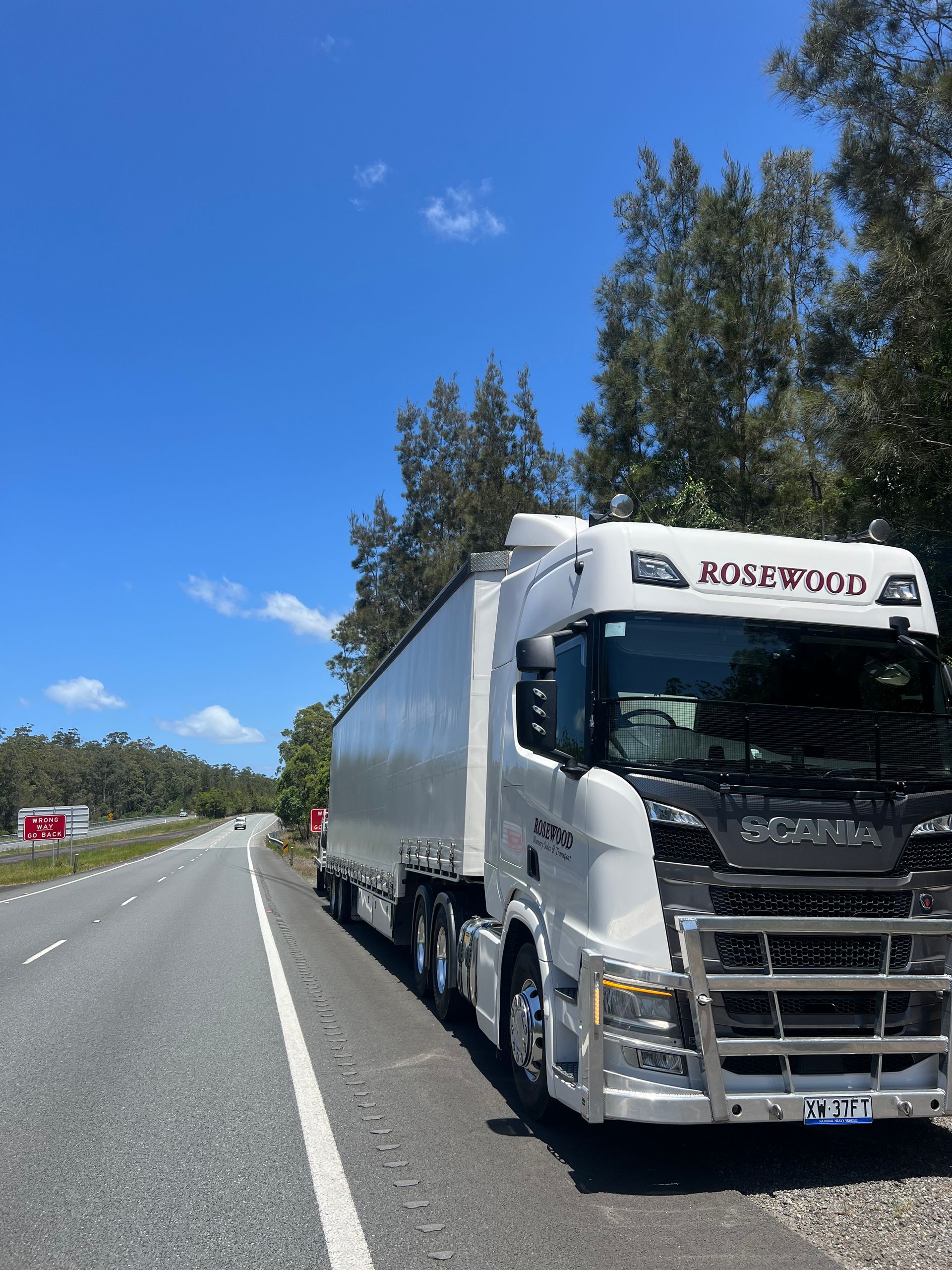 White Semi-truck Parked on the Side of a Highway on a Sunny Day c