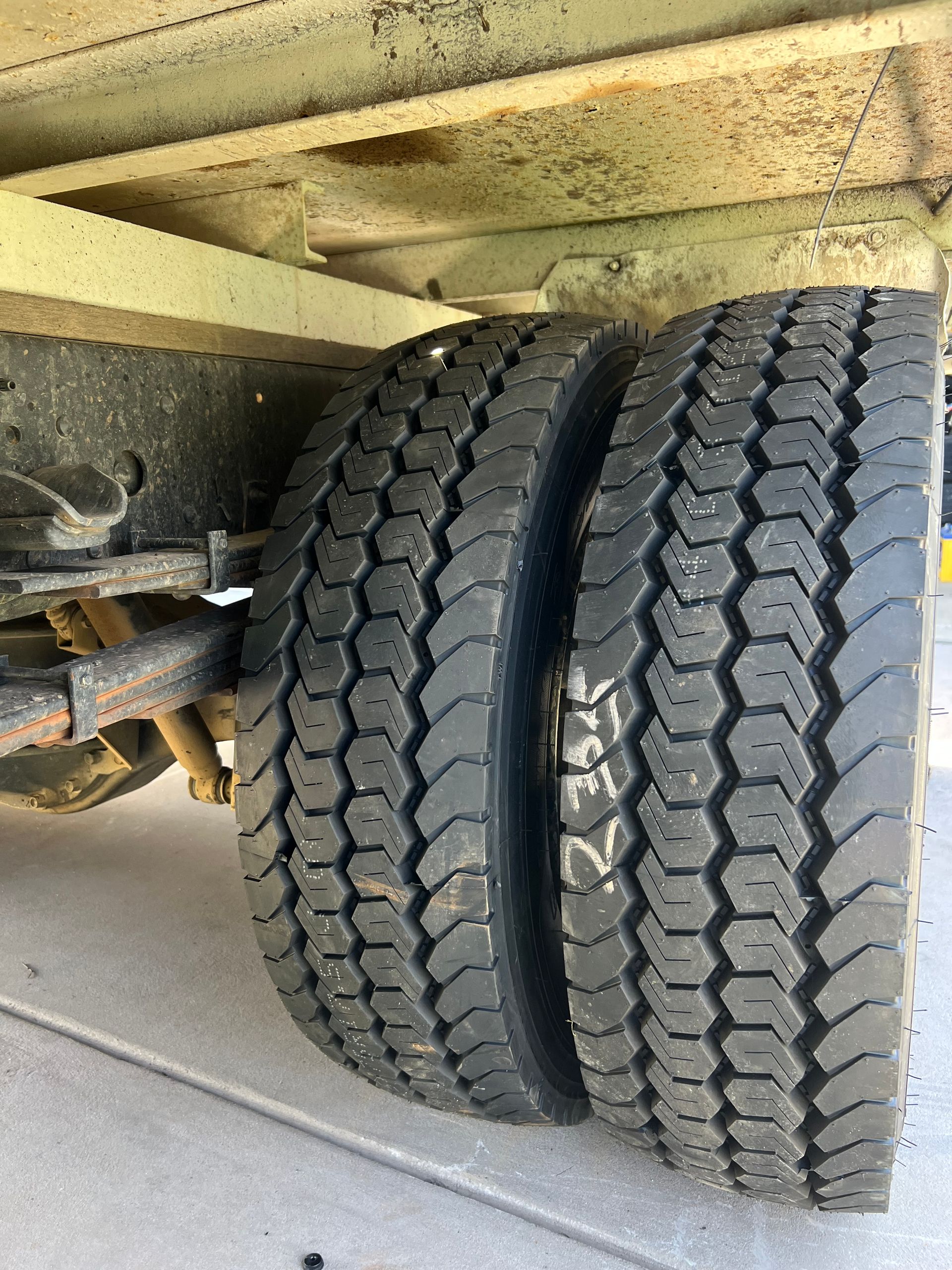 Close-up of Two Truck Tires Under a Vehicle Chassis on Pavement — North Coast Heavy Diesel In Macksville, NSW