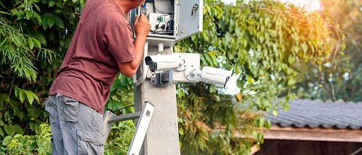 man putting up a security camera