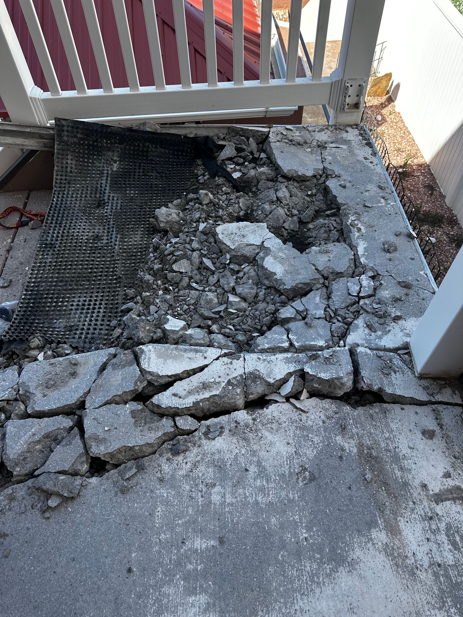 A concrete staircase with a white railing is being repaired.