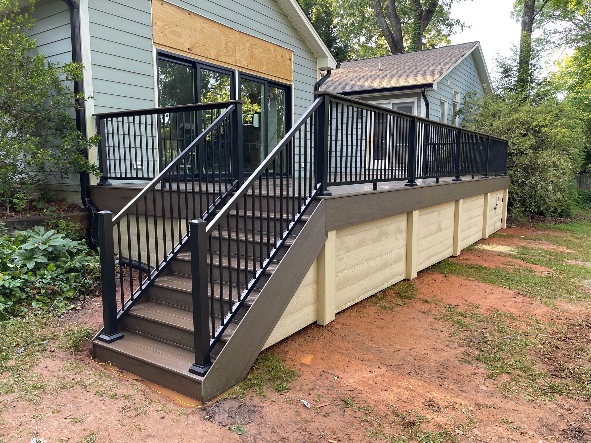 A deck with stairs leading up to a house.