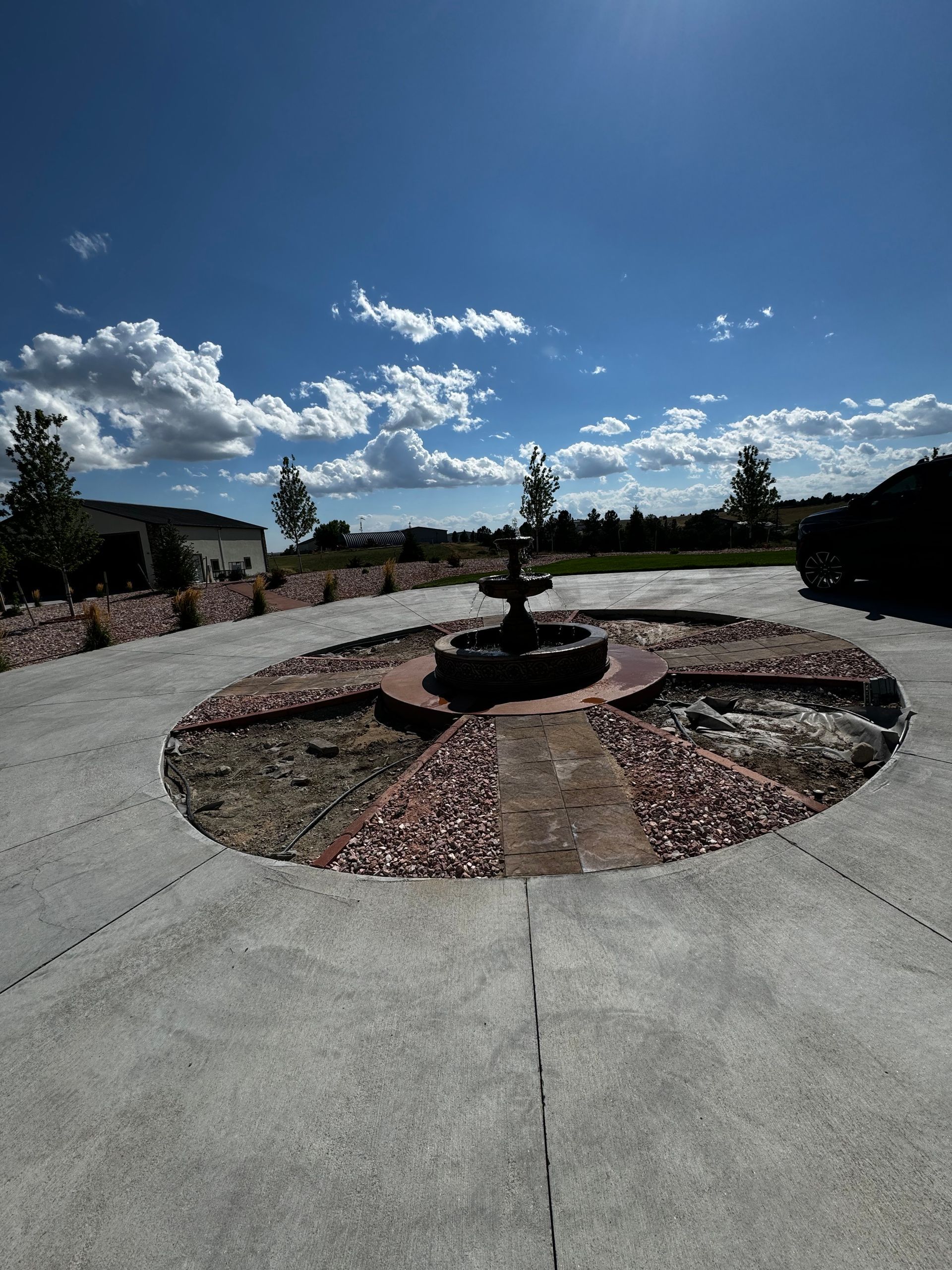 A circular driveway with a fountain in the middle