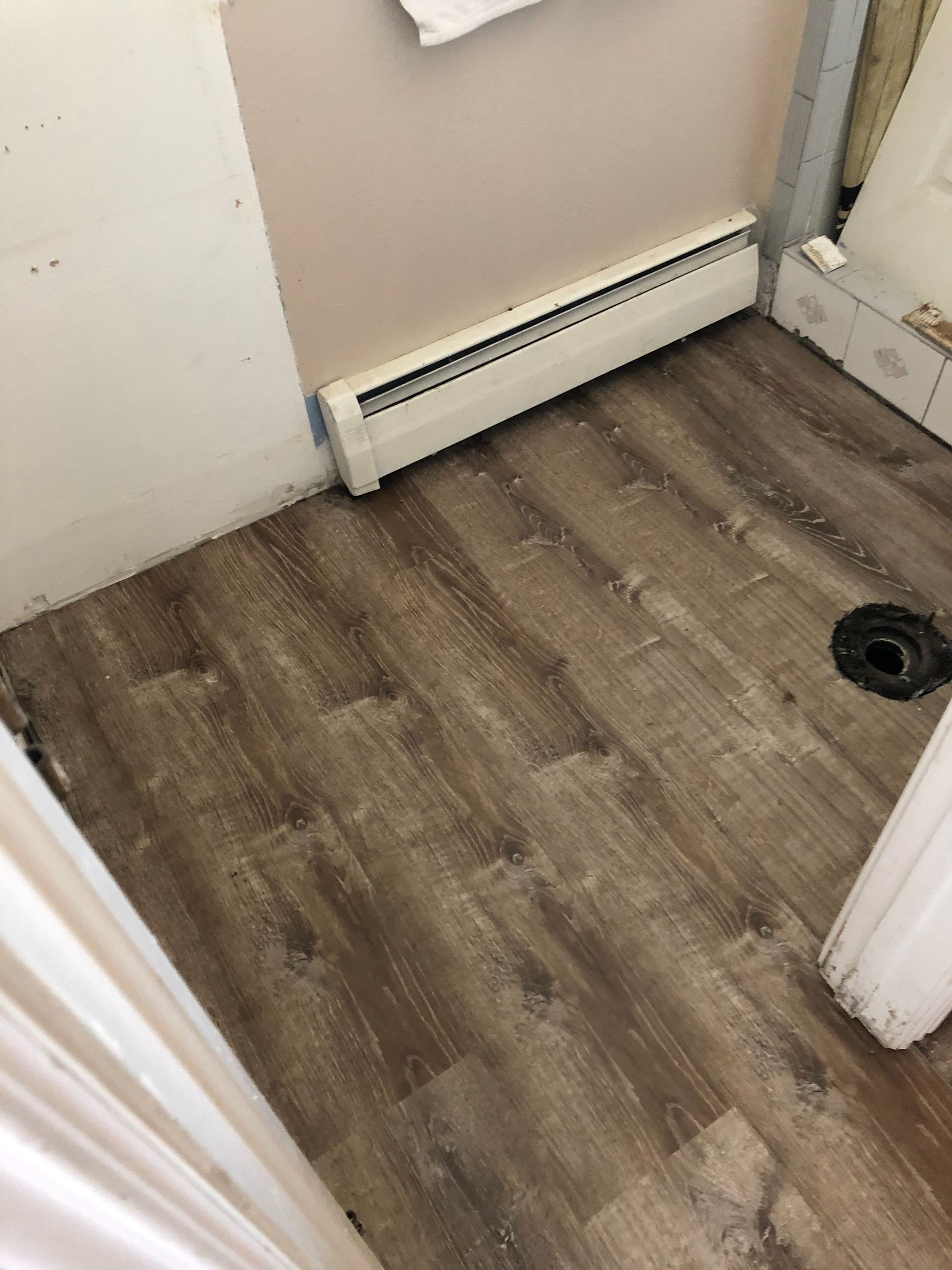 A bathroom with a wooden floor and a toilet.