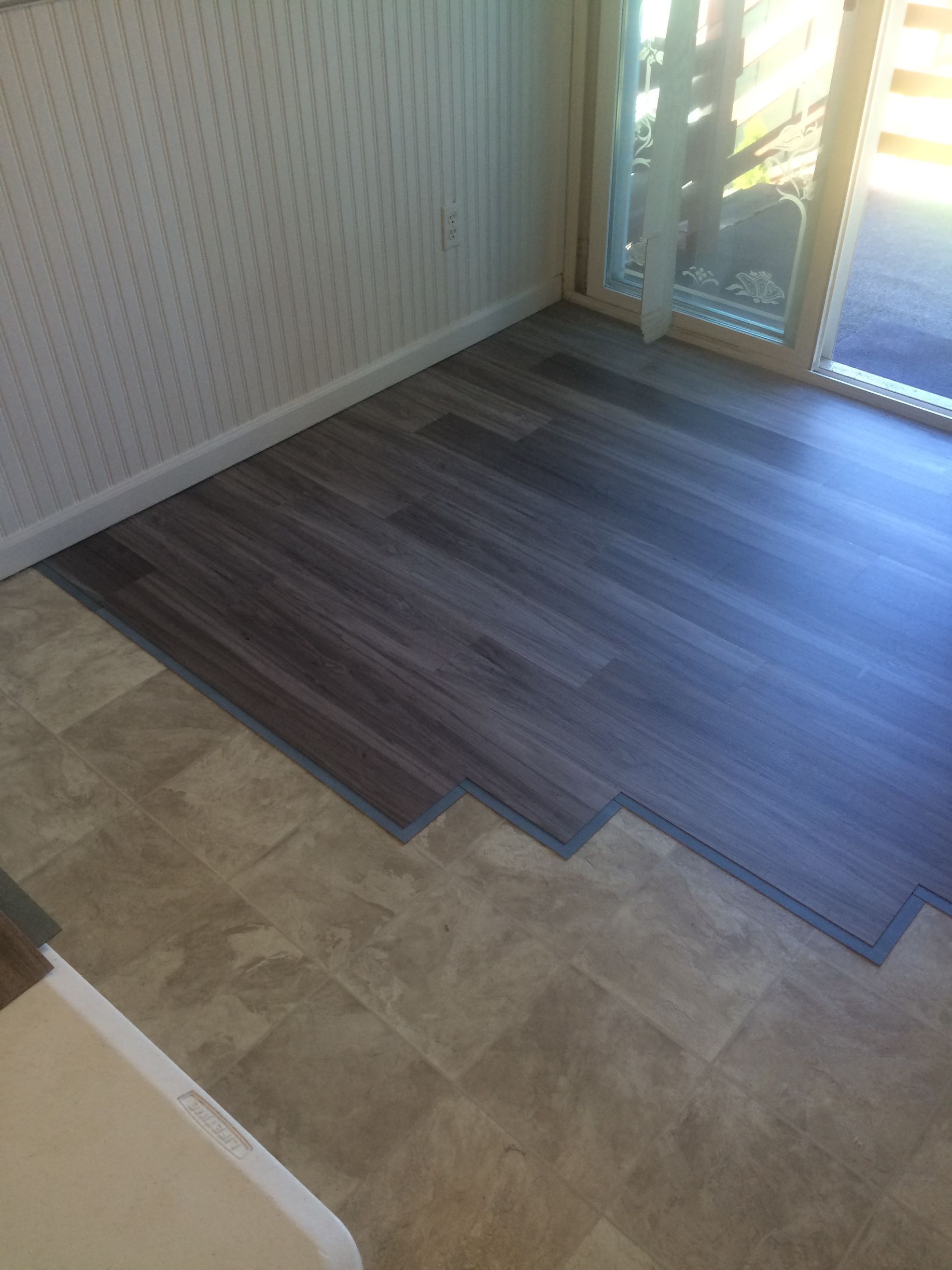 A room with a sliding glass door and a wooden floor.