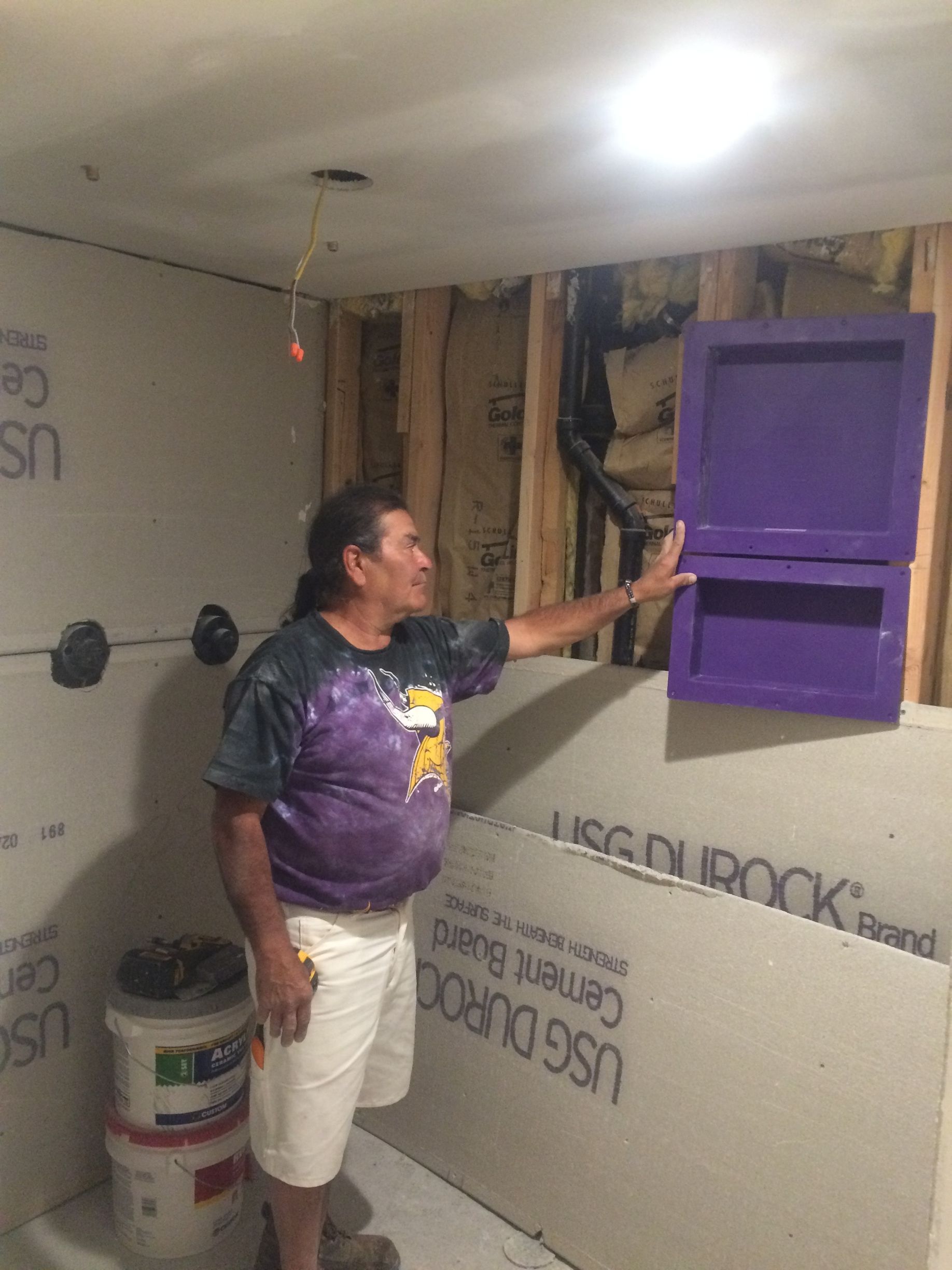 A man is standing in a room holding a purple box.