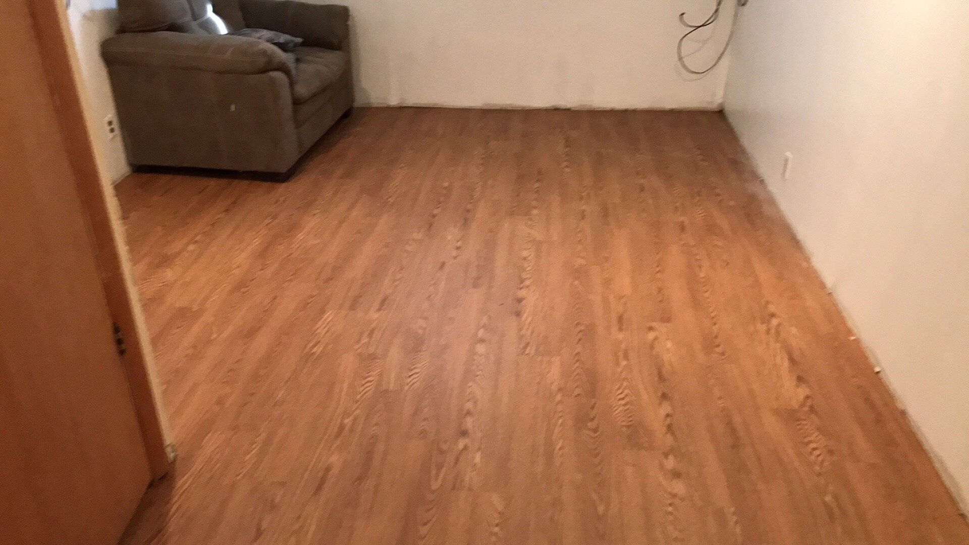 A living room with a wooden floor and a couch.