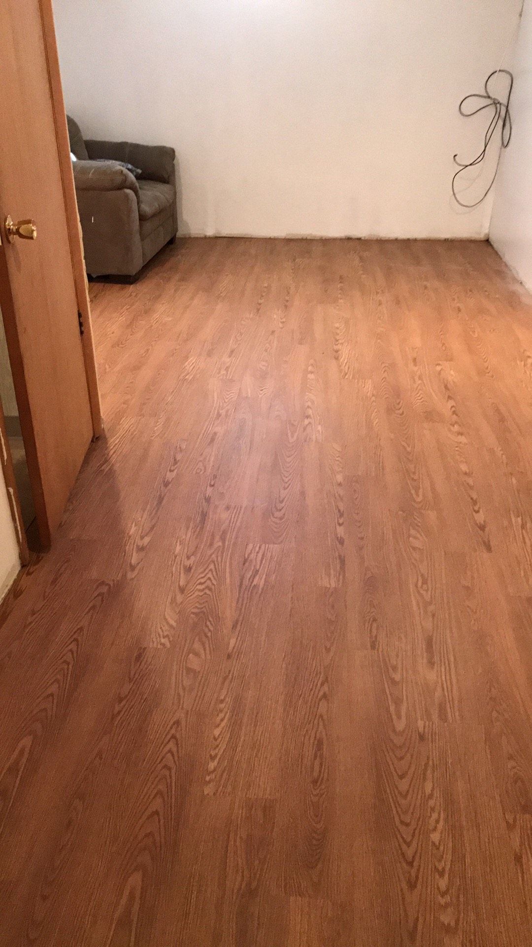 A room with hardwood floors and a couch in it.