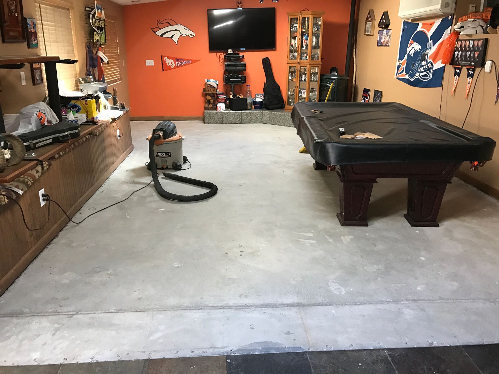 There is a pool table in the middle of the room. During Hardwood floor replacement