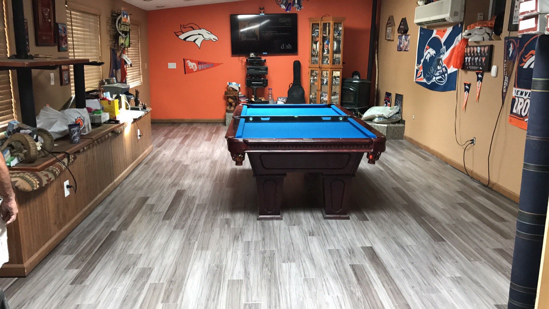 There is a pool table in the middle of the room. After hardwood floor replacement. 