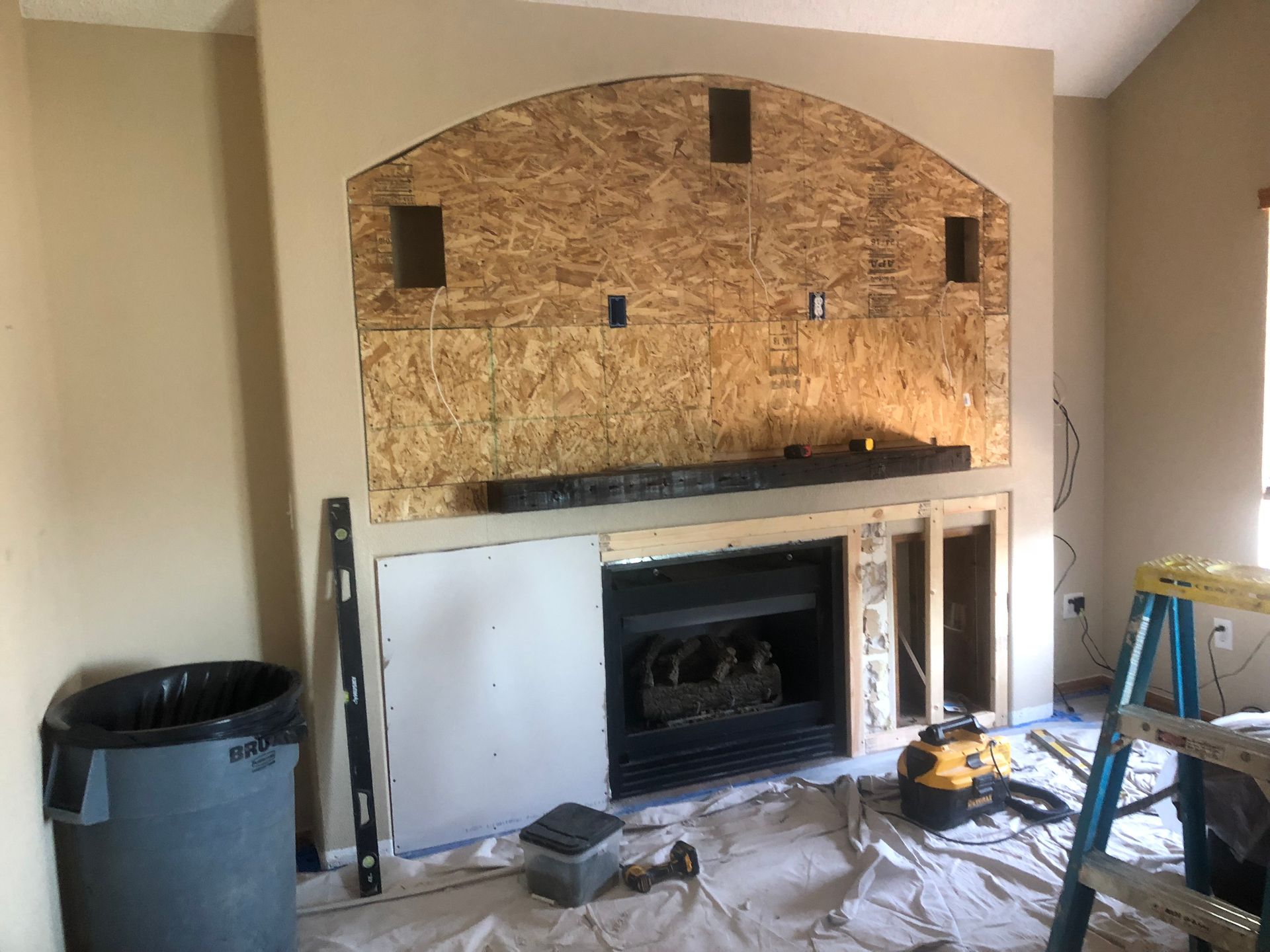 A fireplace is being remodeled in a living room.
