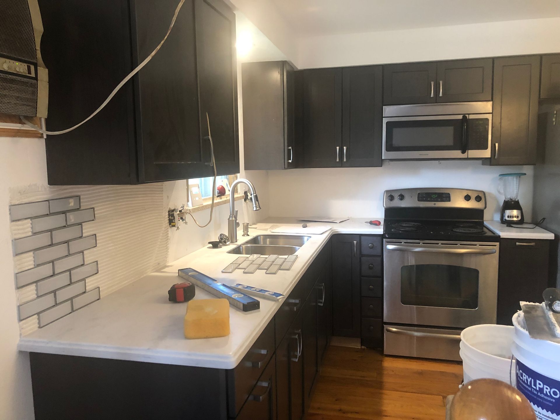 A kitchen with black cabinets and stainless steel appliances