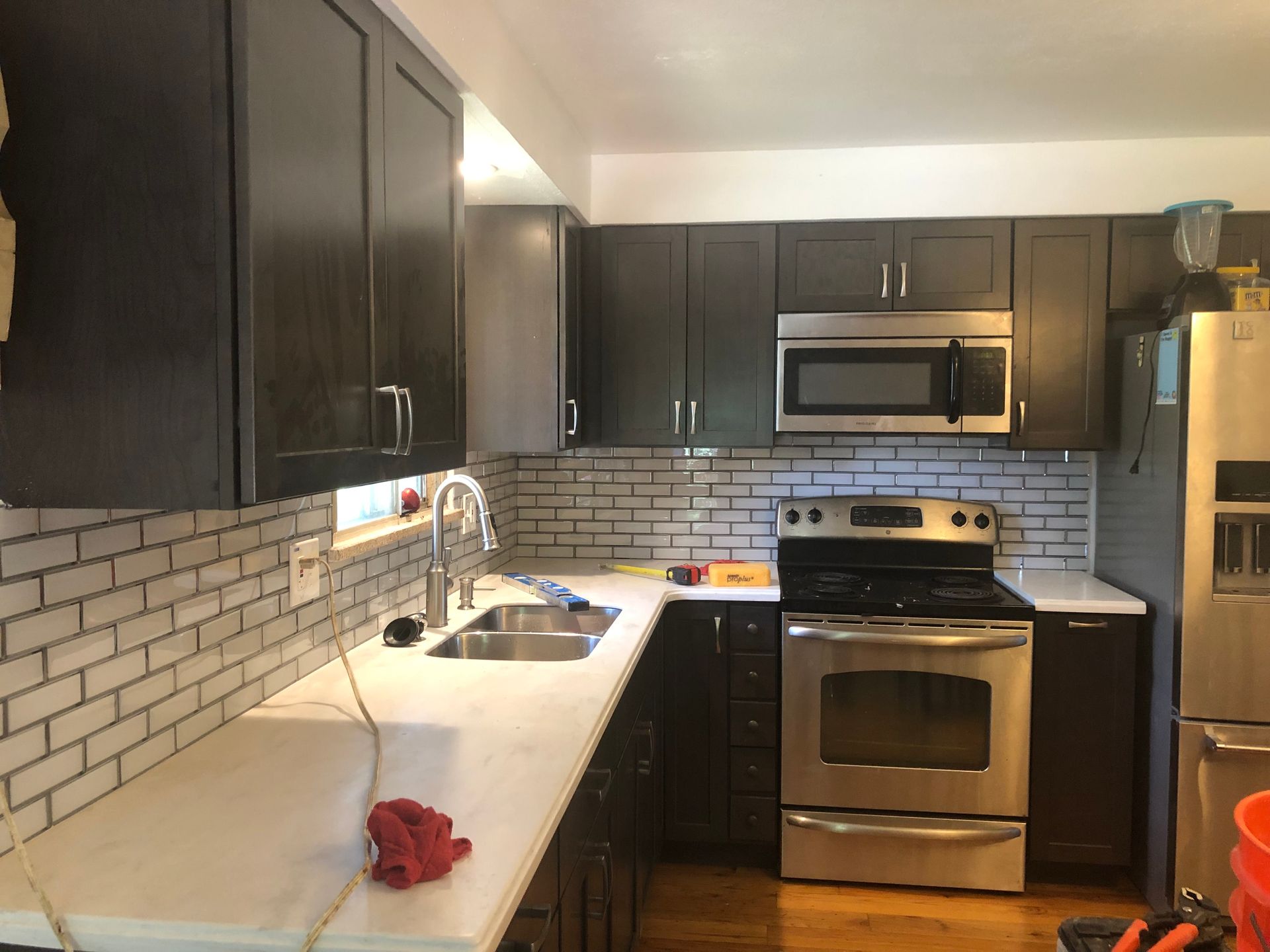 A kitchen with stainless steel appliances and black cabinets